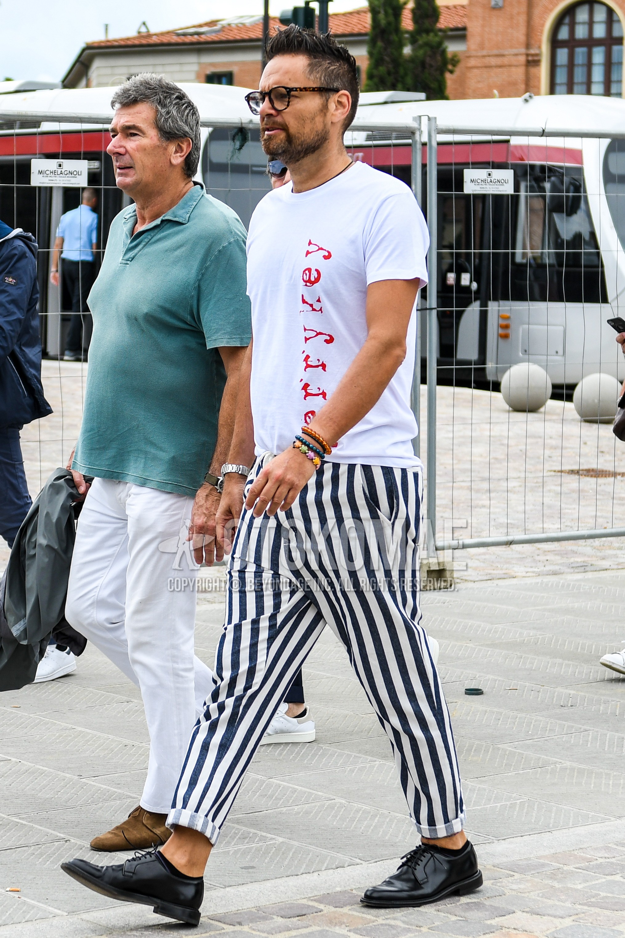 Men's summer outfit with plain glasses, white graphic t-shirt, white navy stripes cotton pants, black plain toe leather shoes.