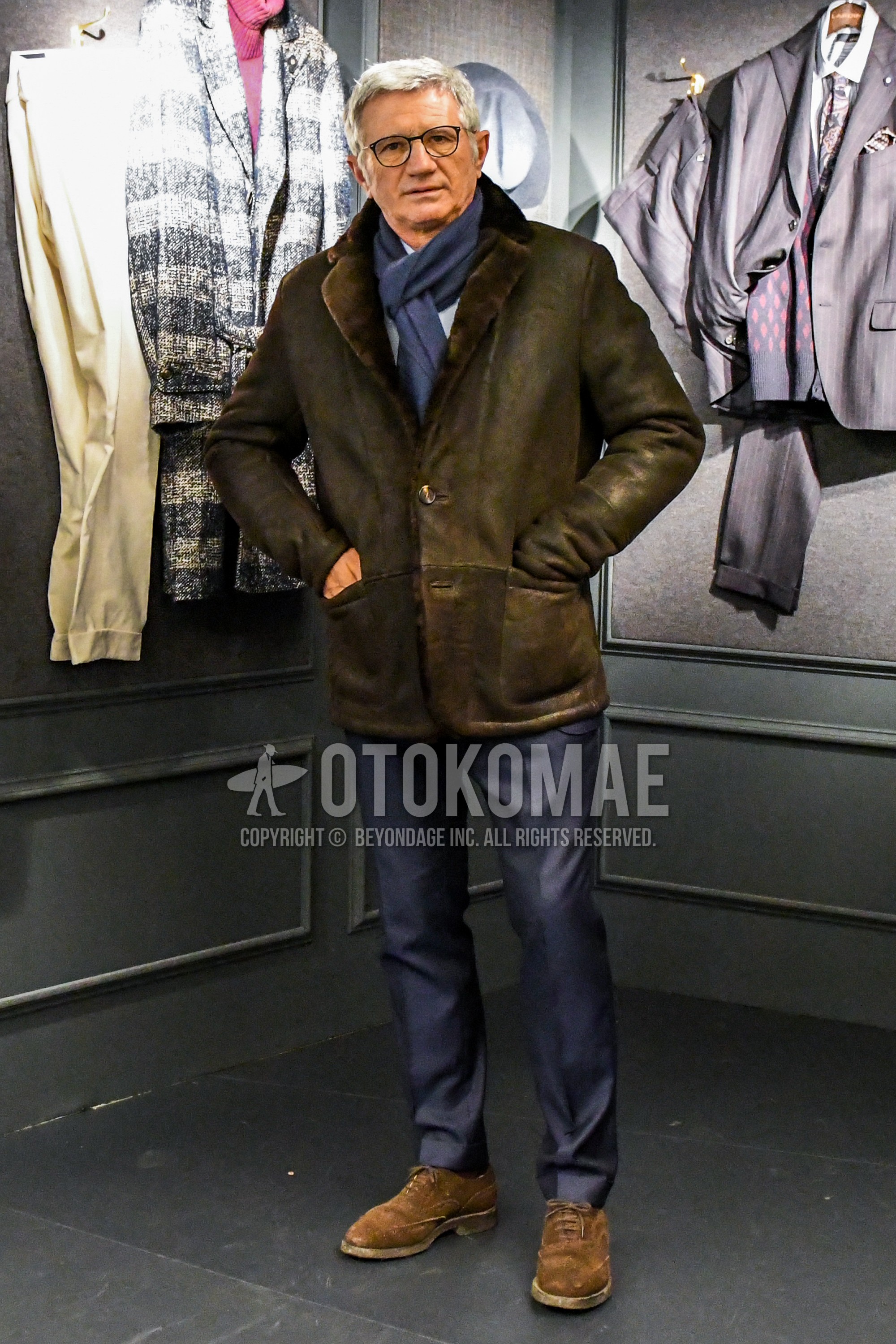 Men's autumn winter outfit with plain glasses, blue plain scarf, olive green plain outerwear, brown wing-tip shoes leather shoes, suede shoes leather shoes, gray plain suit.