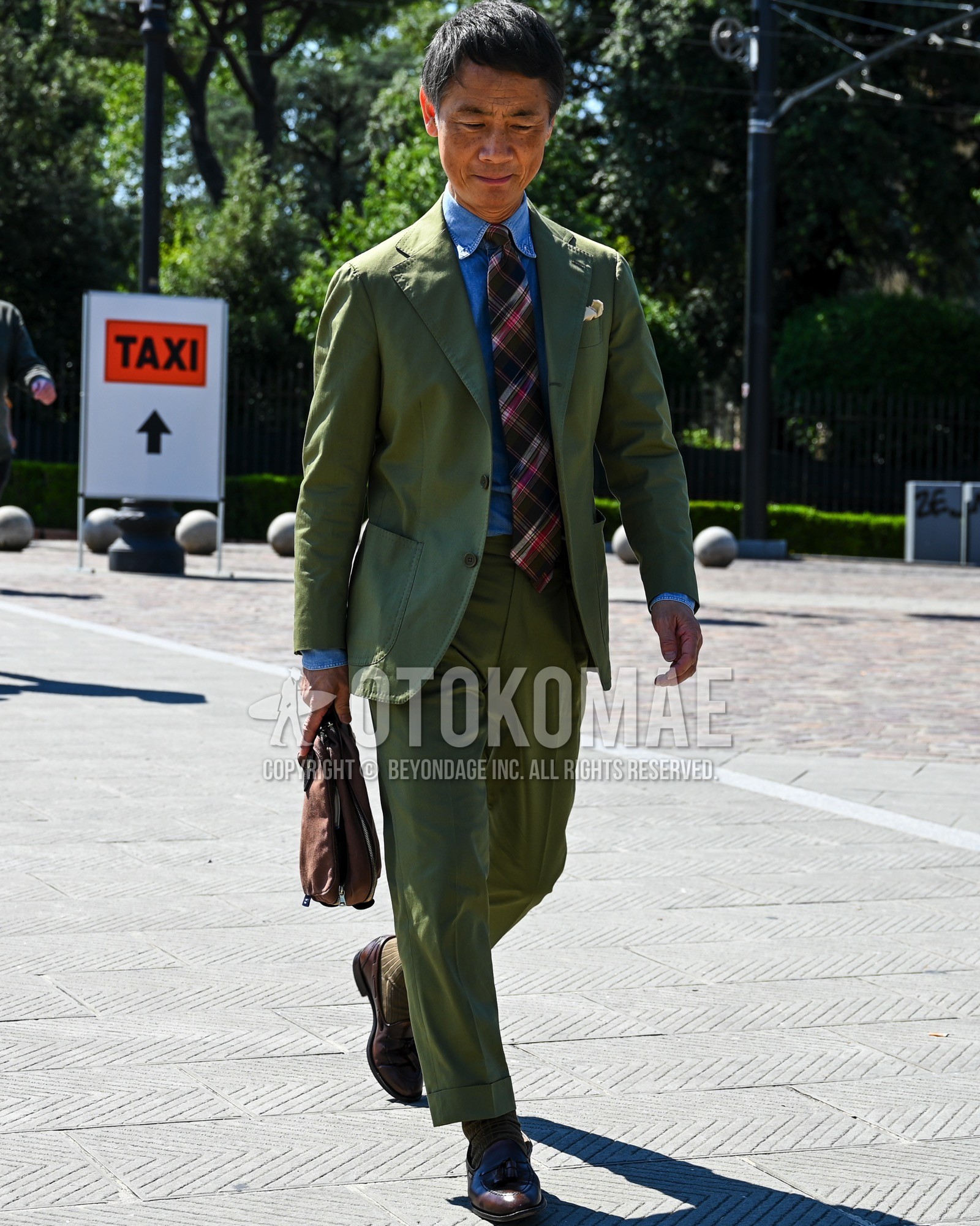 Men's spring summer autumn outfit with blue plain denim shirt/chambray shirt, brown plain socks, brown tassel loafers leather shoes, green plain suit, brown check necktie.