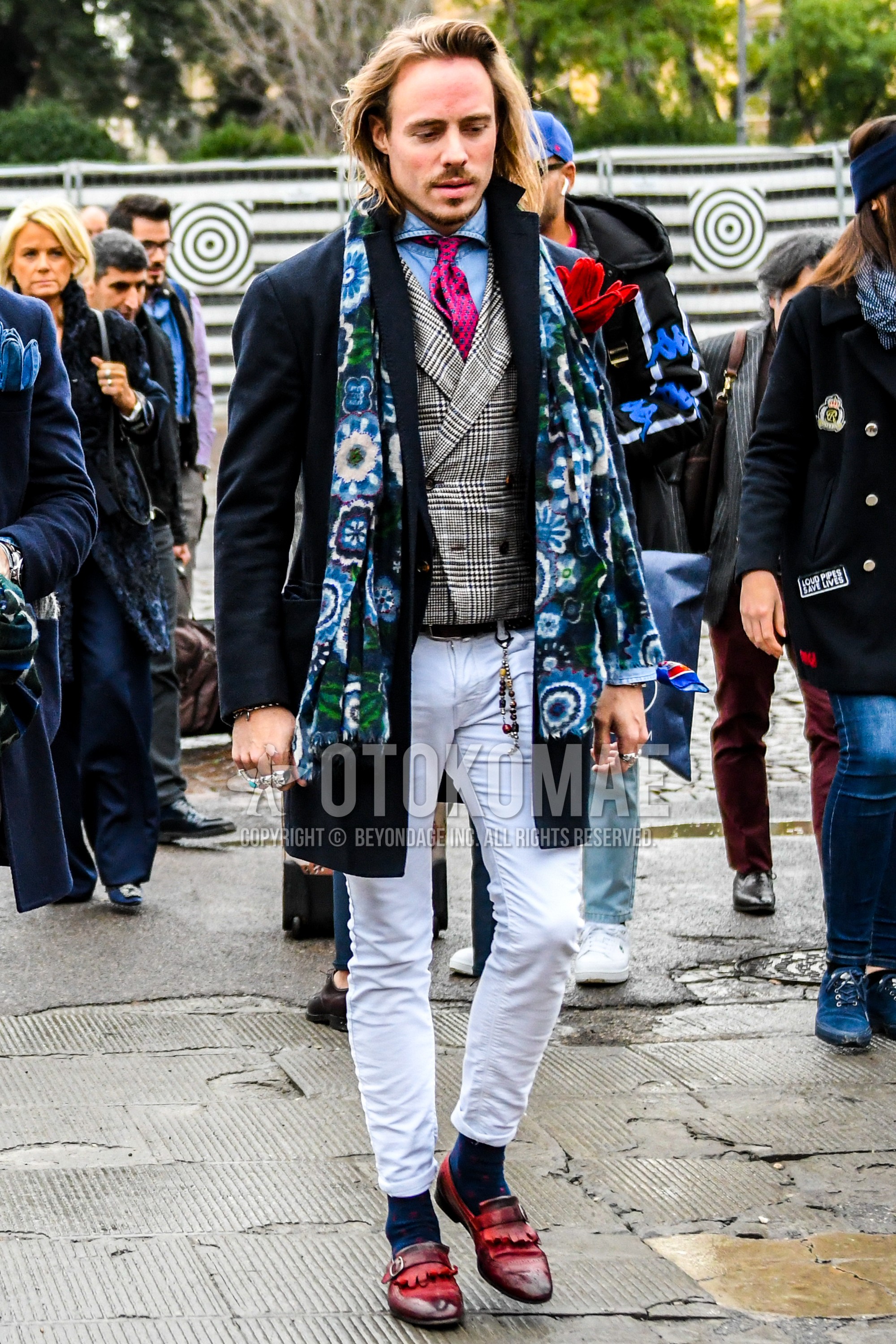 Men's winter outfit with multi-color botanical scarf, navy plain chester coat, light blue plain shirt, gray check gilet, white plain denim/jeans, navy dots socks, red  loafers leather shoes, pink dots necktie.