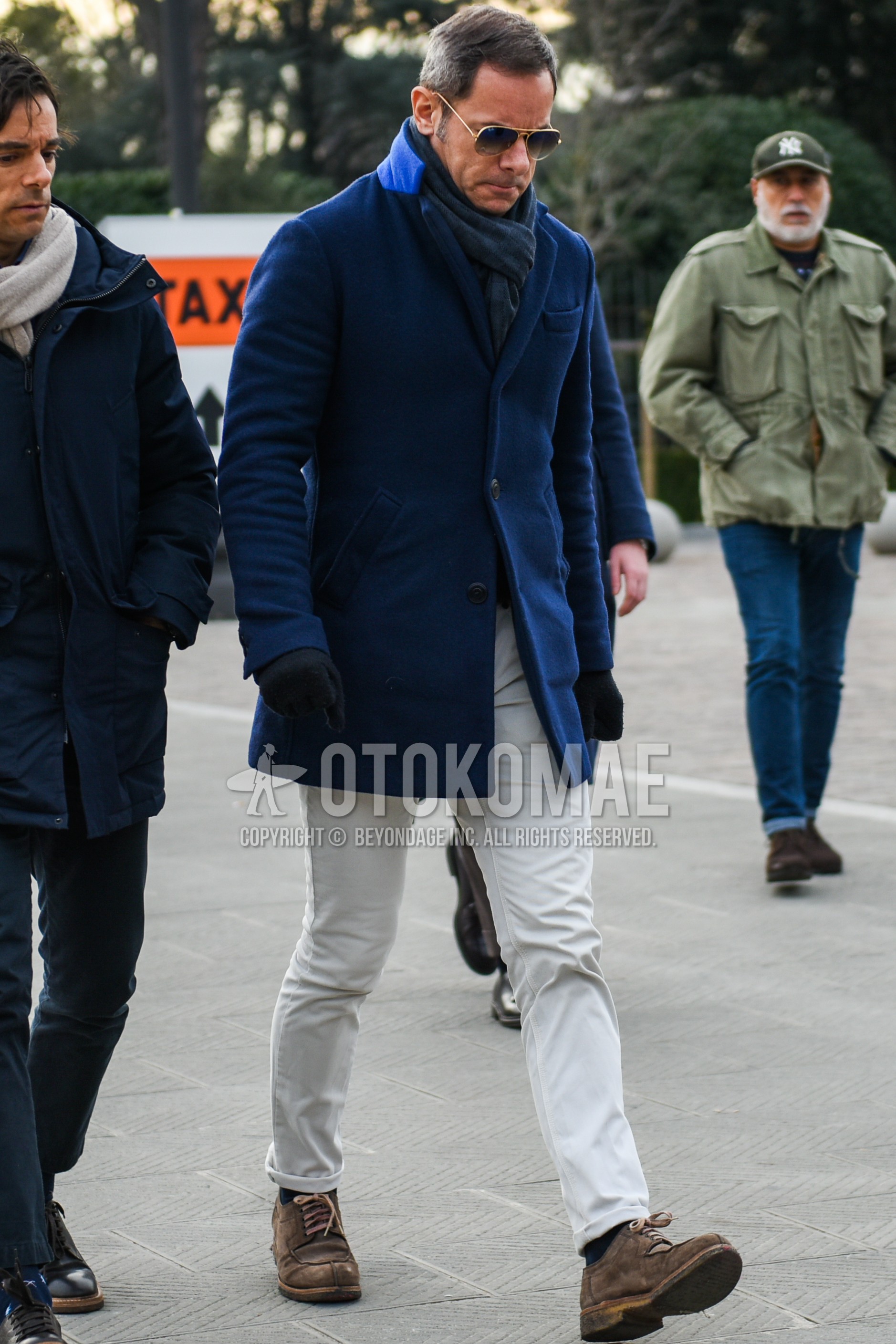 Men's autumn winter outfit with gold plain sunglasses, gray plain scarf, blue plain chester coat, white plain cotton pants, navy plain socks, brown u-tip shoes leather shoes.