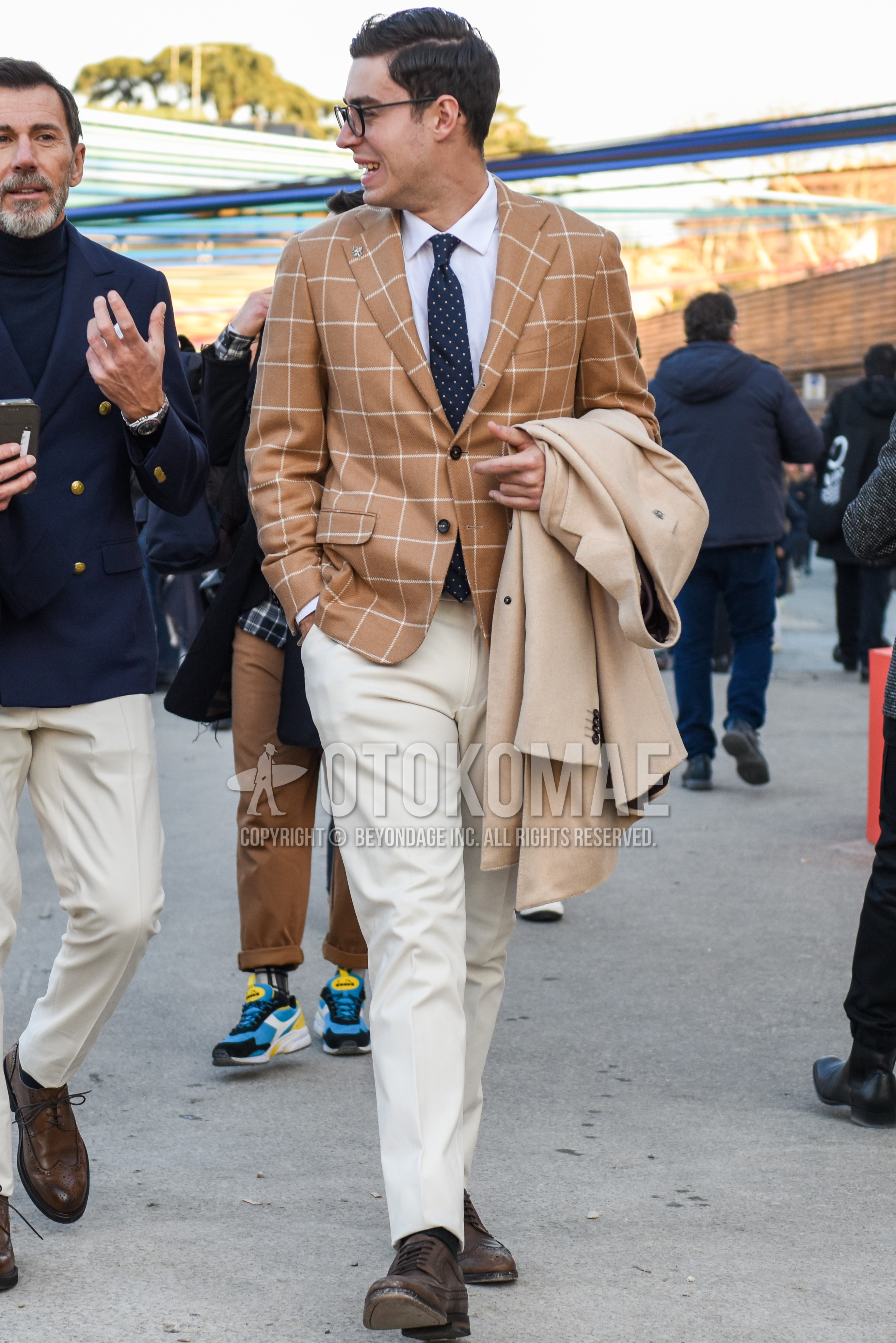 Men's spring autumn outfit with black plain glasses, beige check tailored jacket, white plain shirt, white plain slacks, white plain ankle pants, black plain socks, brown wing-tip shoes leather shoes, navy dots necktie.