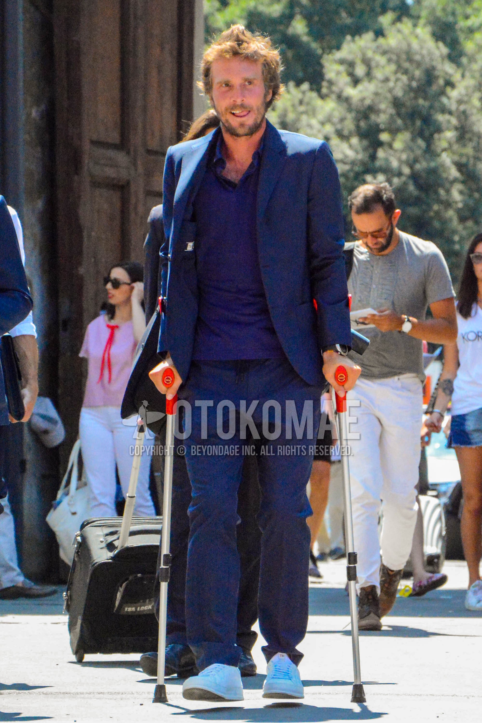 Men's spring summer autumn outfit with navy plain polo shirt, white low-cut sneakers, navy plain suit.