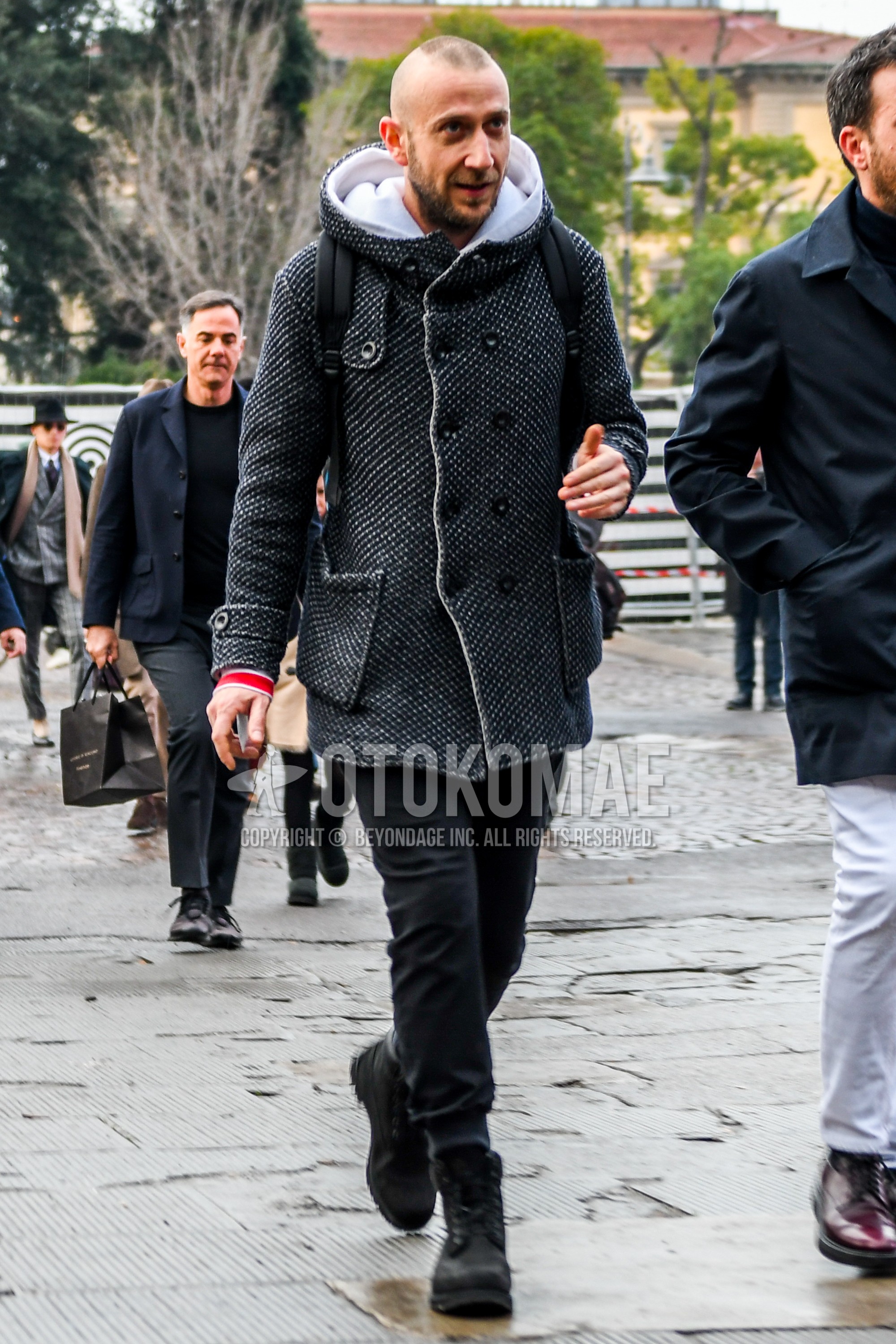 Men's autumn winter outfit with black white outerwear hooded coat, black plain jogger pants/ribbed pants, black  boots.