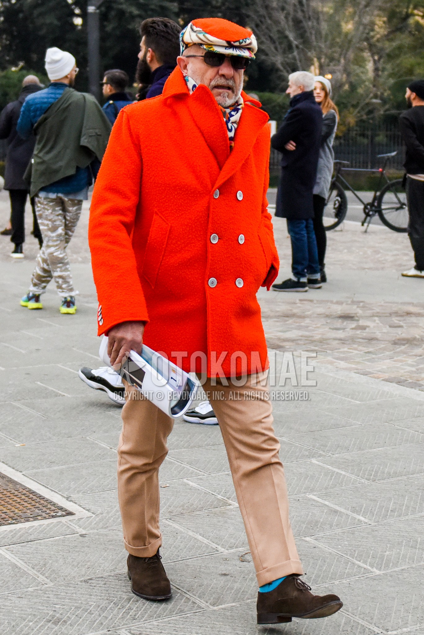 Men's autumn winter outfit with orange cap, black plain sunglasses, multi-color scarf scarf, orange plain p coat, beige plain slacks, light blue socks socks, brown hole cut leather shoes.