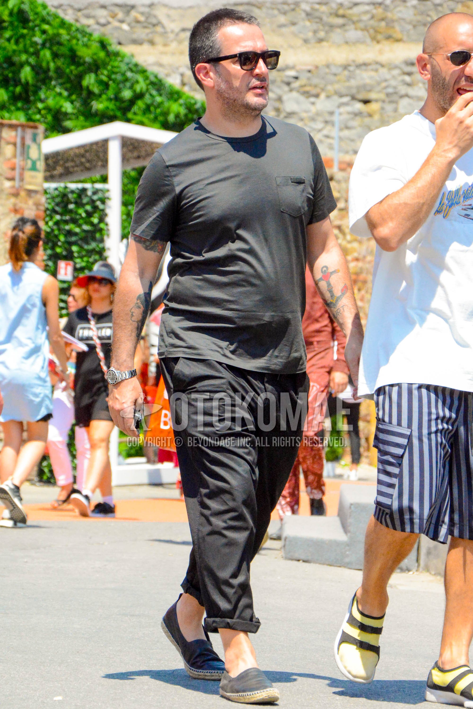 Men's summer outfit with plain sunglasses, black plain t-shirt, black plain wide pants, black plain espadrille.
