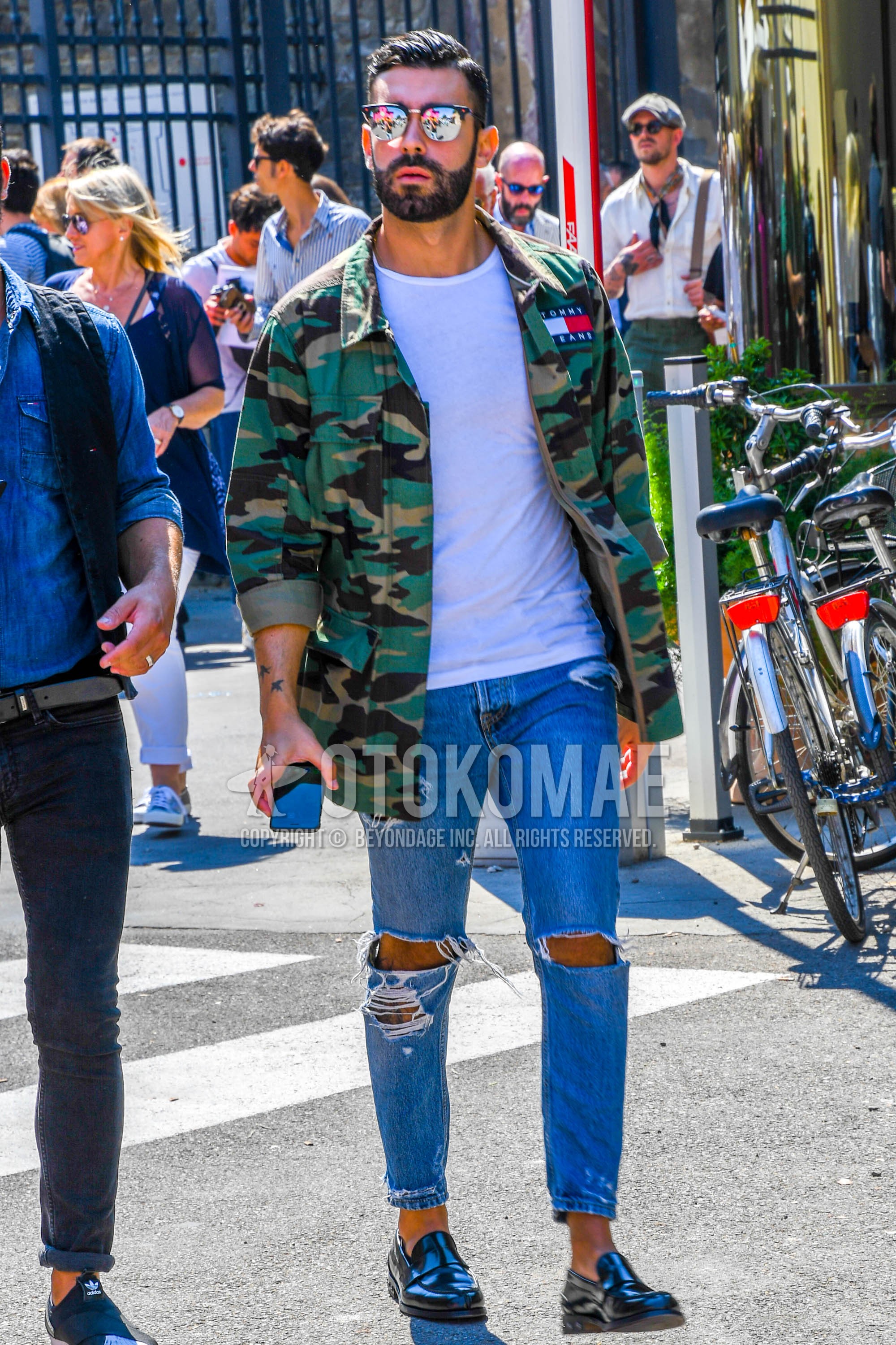 Men's spring summer autumn outfit with plain sunglasses, green camouflage M-65, white plain t-shirt, blue plain damaged jeans, black coin loafers leather shoes.