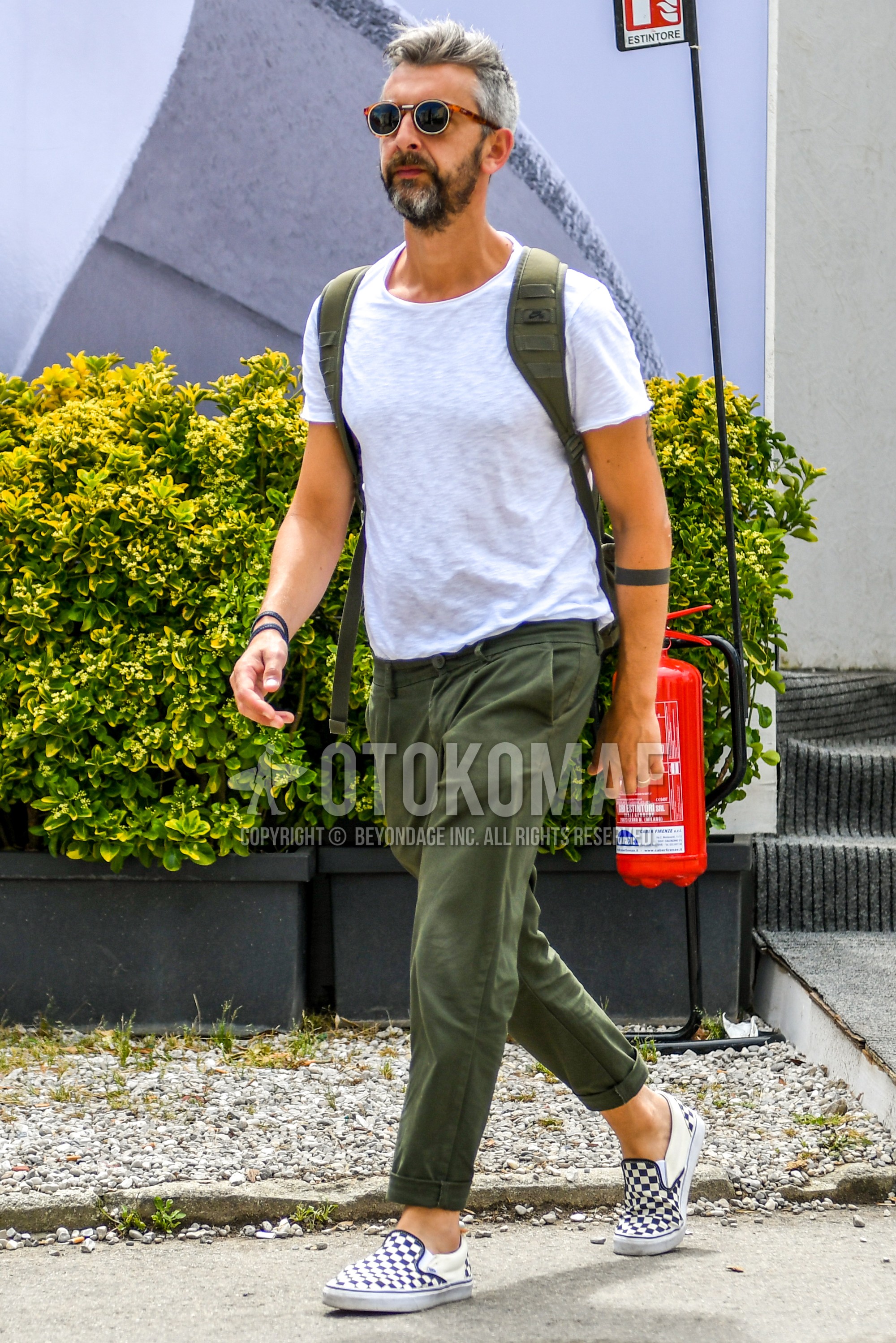 Men's summer outfit with plain sunglasses, white plain t-shirt, olive green plain ankle pants, white low-cut sneakers.