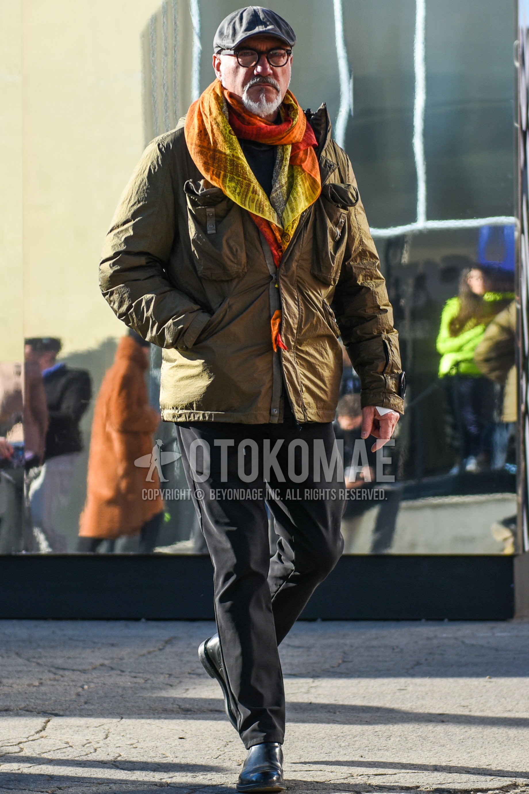 Men's autumn winter outfit with gray plain hunting cap, brown tortoiseshell glasses, multi-color scarf scarf, beige plain military jacket, black plain easy pants, black side-gore boots.