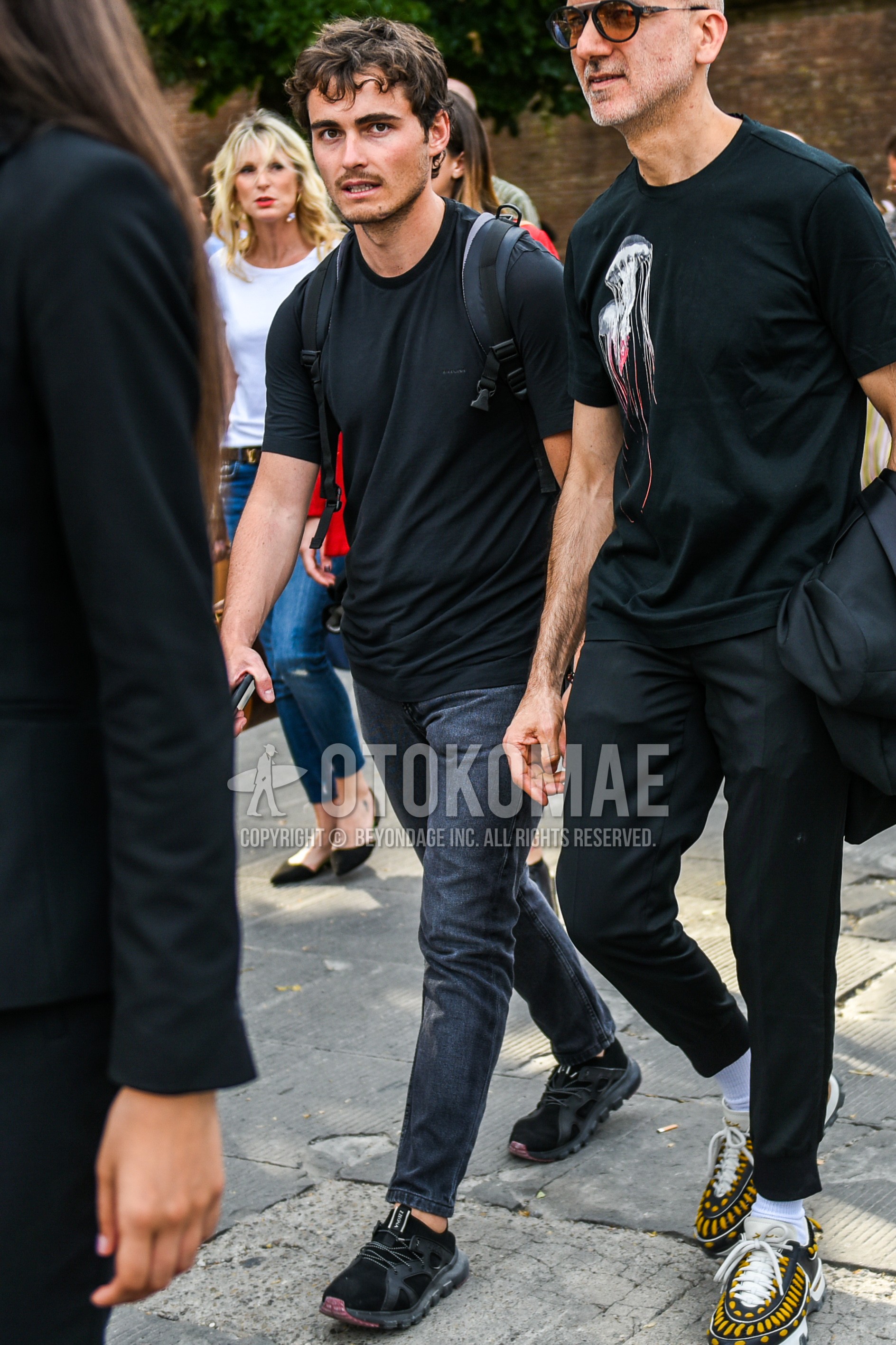 Men's summer outfit with black plain t-shirt, dark gray plain denim/jeans, black low-cut sneakers.