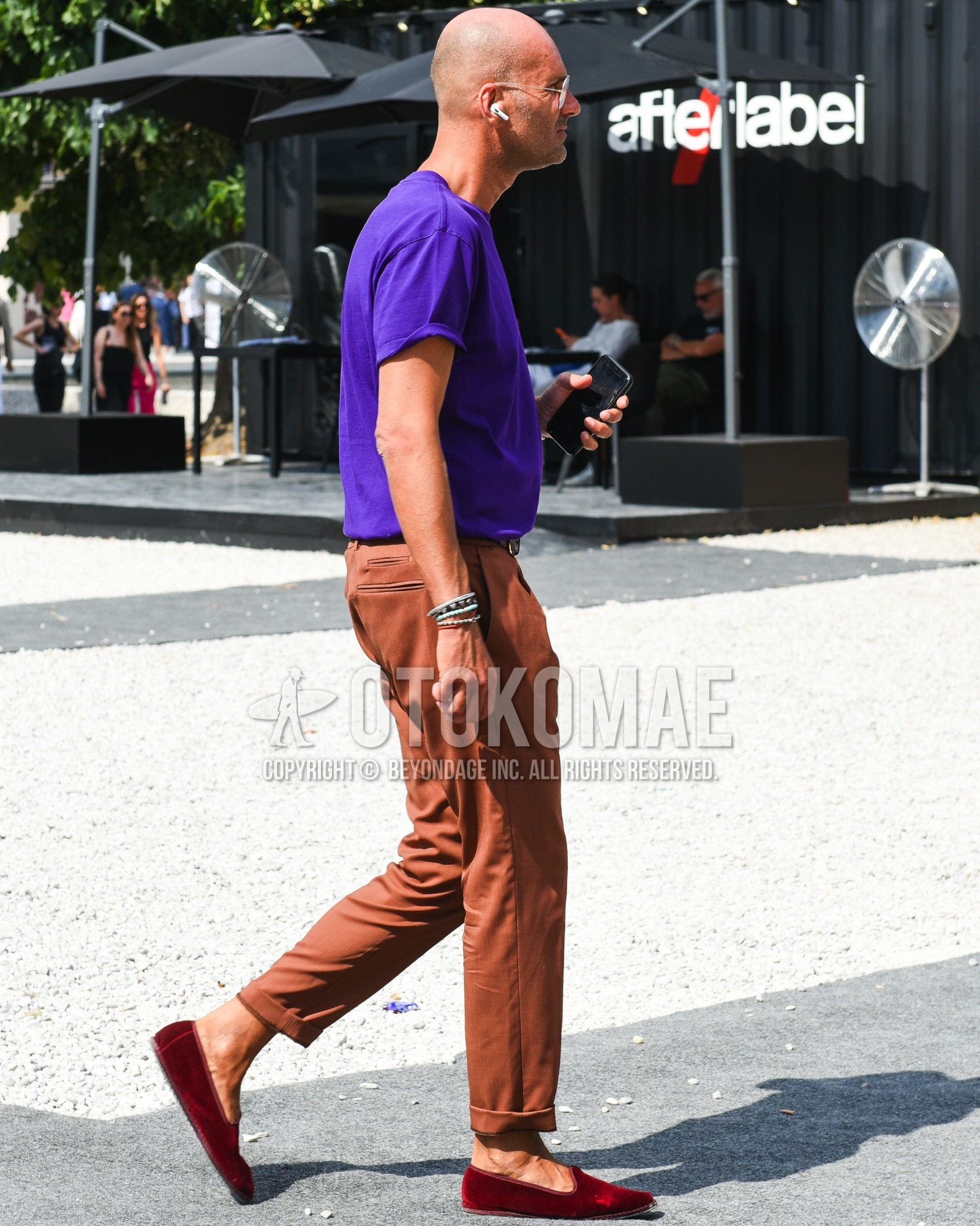Men's spring summer outfit with silver plain sunglasses, purple plain t-shirt, brown plain slacks, red plain espadrille.