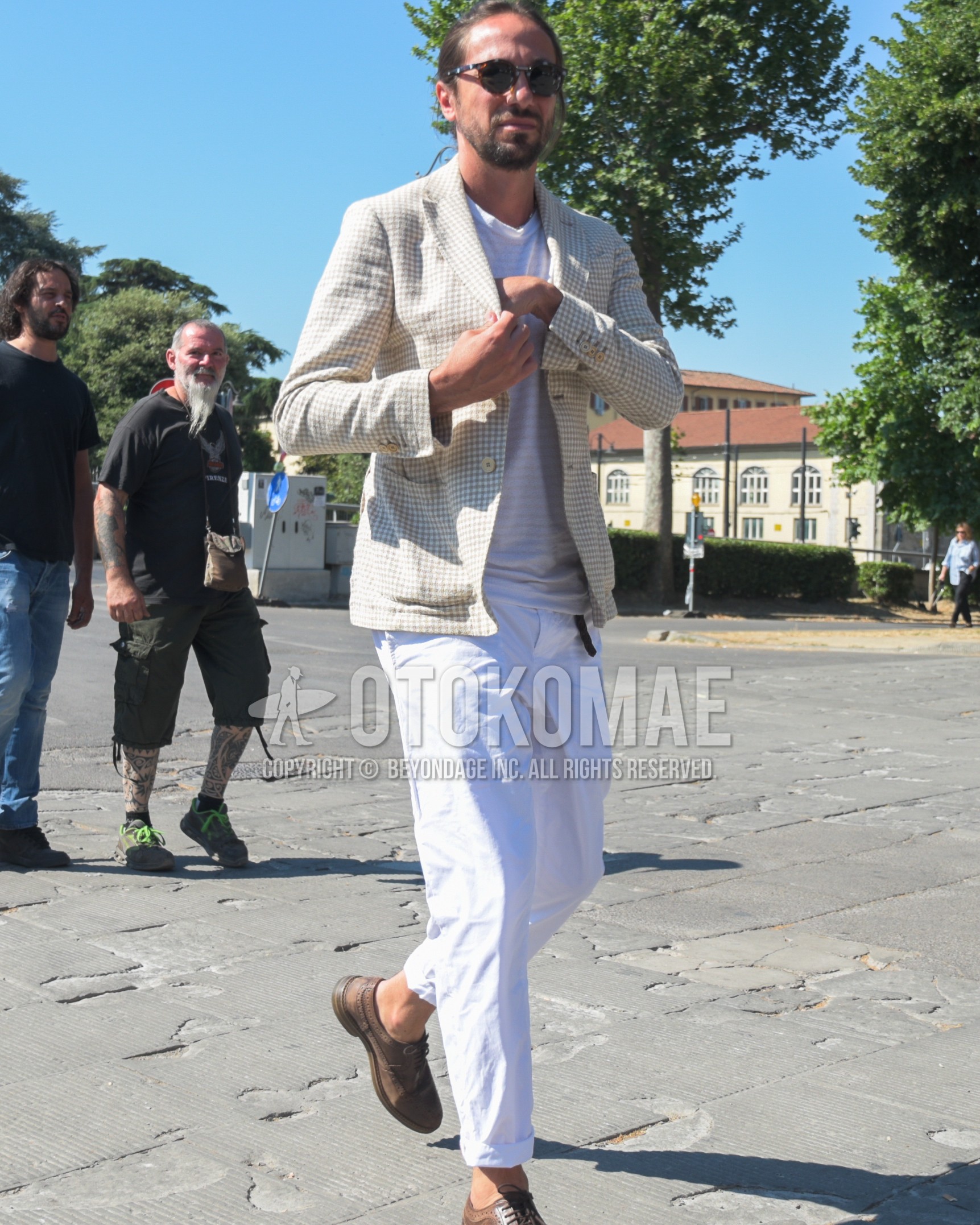 Men's spring summer autumn outfit with black tortoiseshell sunglasses, beige check tailored jacket, white horizontal stripes t-shirt, white plain cotton pants, brown brogue shoes leather shoes.