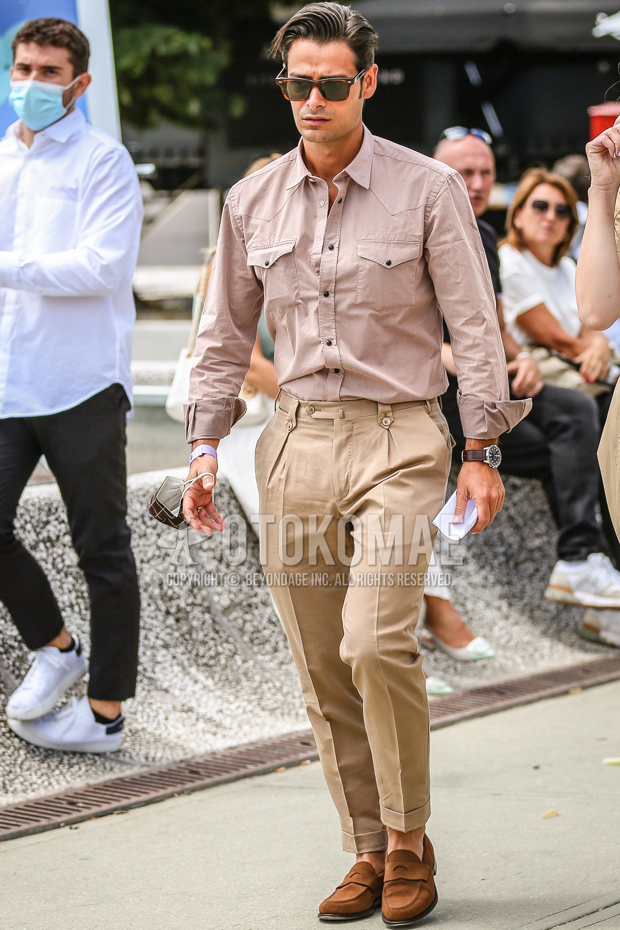 Men's spring summer outfit with brown tortoiseshell sunglasses, pink beige plain shirt, brown plain slacks, brown coin loafers leather shoes, brown suede shoes leather shoes.