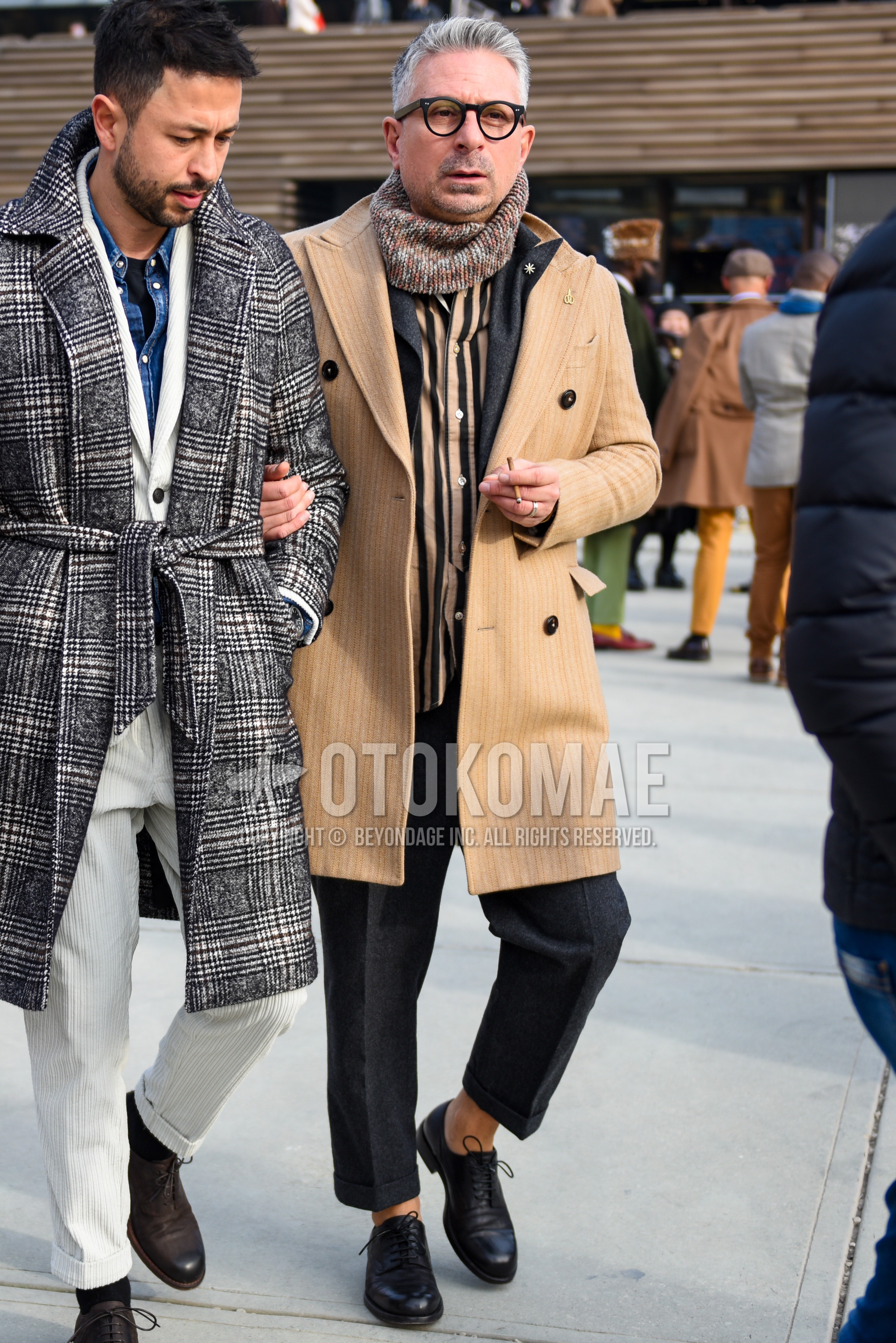 Men's autumn winter outfit with black plain glasses, multi-color scarf snood, beige plain chester coat, black beige stripes shirt, black plain toe leather shoes, gray plain suit.
