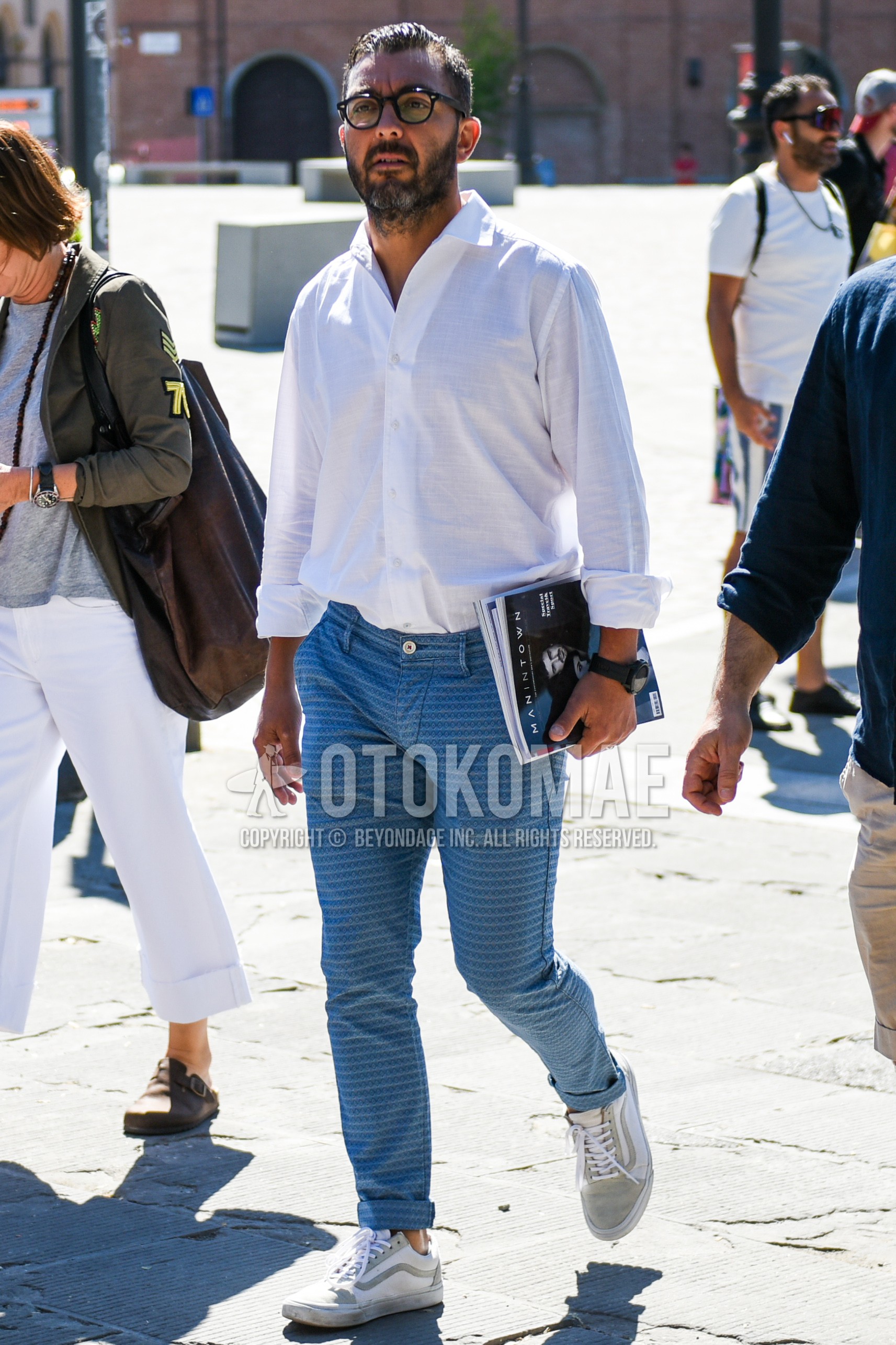 Men's summer outfit with black plain glasses, white plain shirt, light blue blue bottoms damaged jeans, white gray low-cut sneakers.