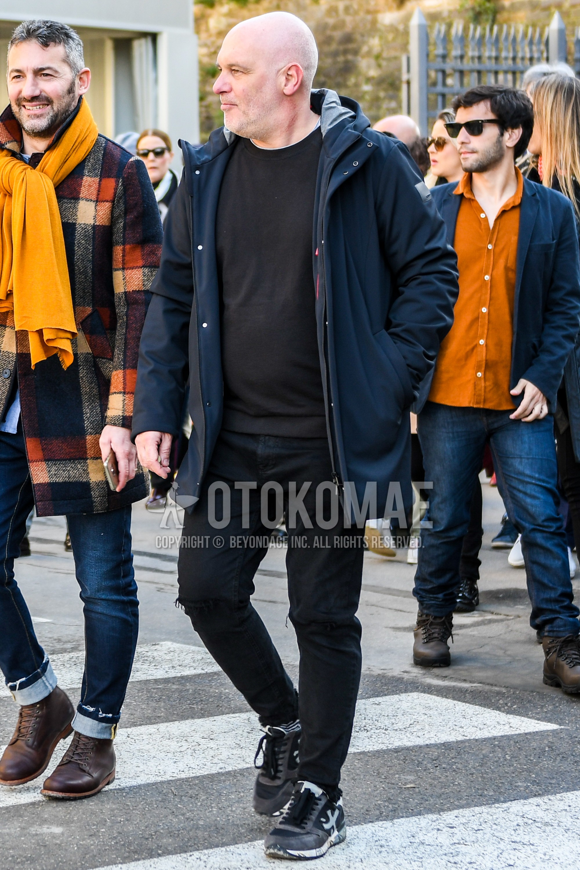 Men's winter outfit with black plain down jacket, black plain sweatshirt, black plain damaged jeans, gray black low-cut sneakers.