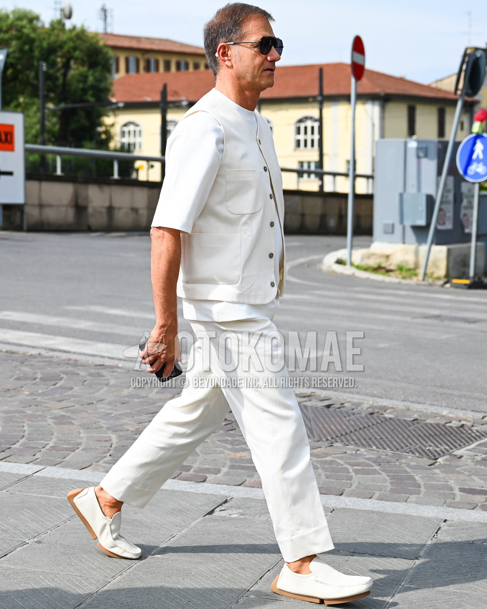 Men's spring summer outfit with black plain sunglasses, white plain casual vest, white plain t-shirt, white plain slacks, white  loafers leather shoes.