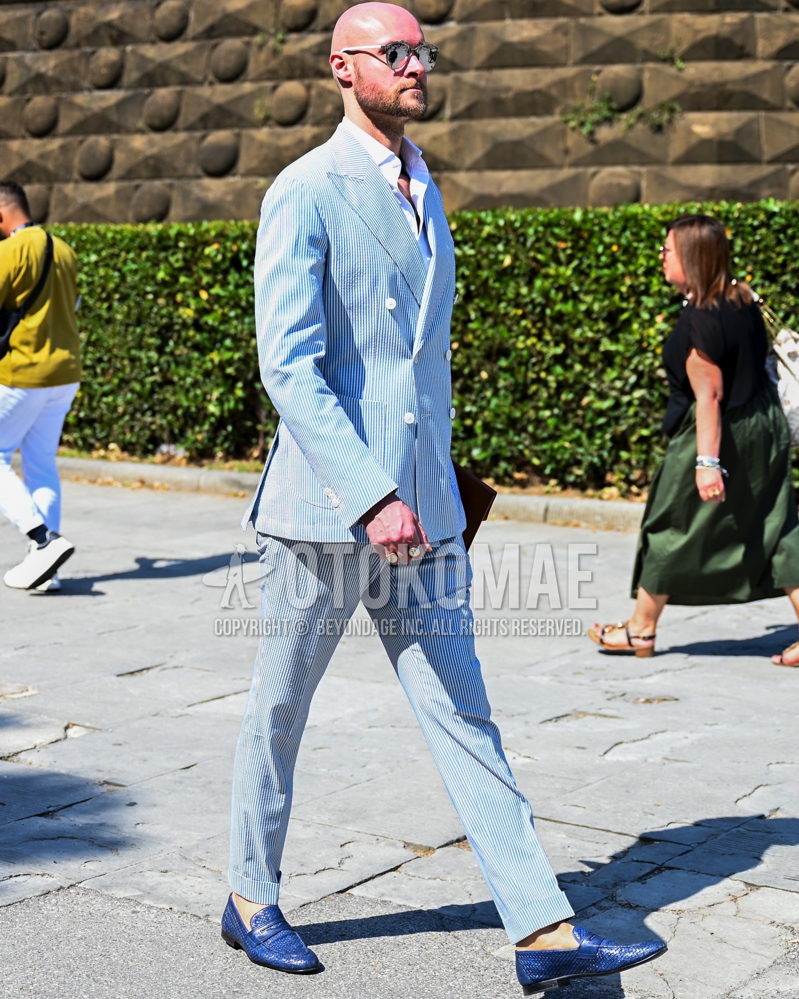 Men's spring summer autumn outfit with silver plain sunglasses, white plain shirt, blue coin loafers leather shoes, light blue stripes suit.