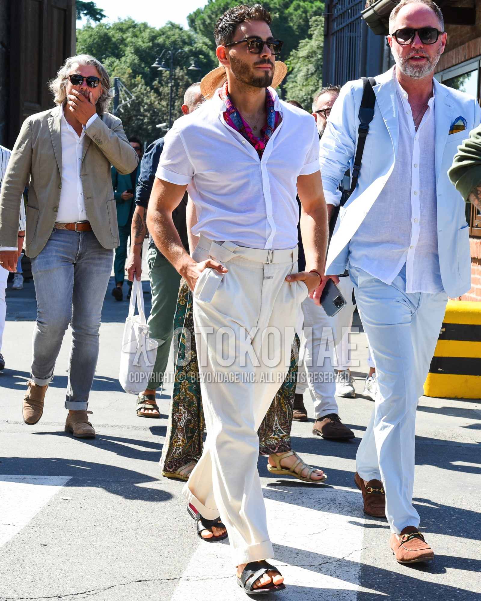Men's spring summer outfit with black tortoiseshell sunglasses, purple graphic scarf, white plain shirt, white plain tape belt, white plain cotton pants, black leather sandals.