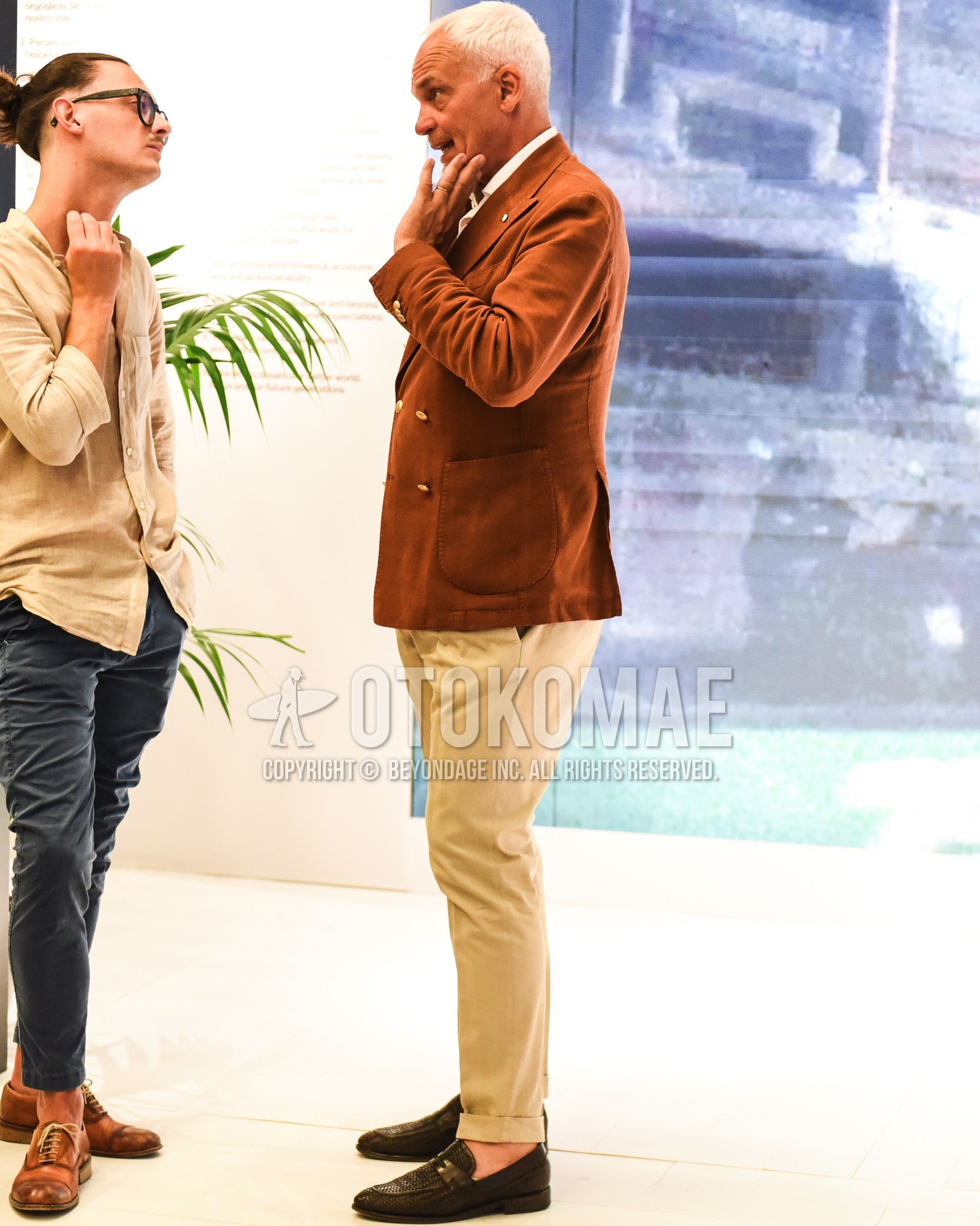 Men's spring summer outfit with brown plain tailored jacket, white plain shirt, beige plain slacks, brown coin loafers leather shoes.