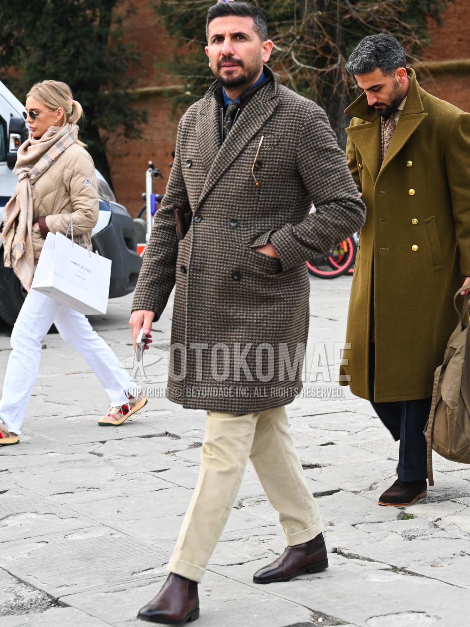 Men's autumn winter outfit with brown check chester coat, blue plain denim shirt/chambray shirt, beige plain slacks, brown side-gore boots, dark gray necktie necktie.