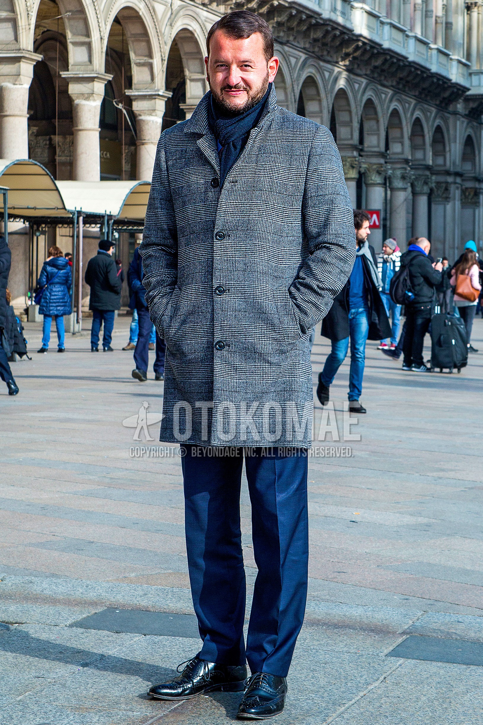 Men's autumn winter outfit with navy plain scarf, gray check stenkarrer coat, navy plain slacks, black wing-tip shoes leather shoes.