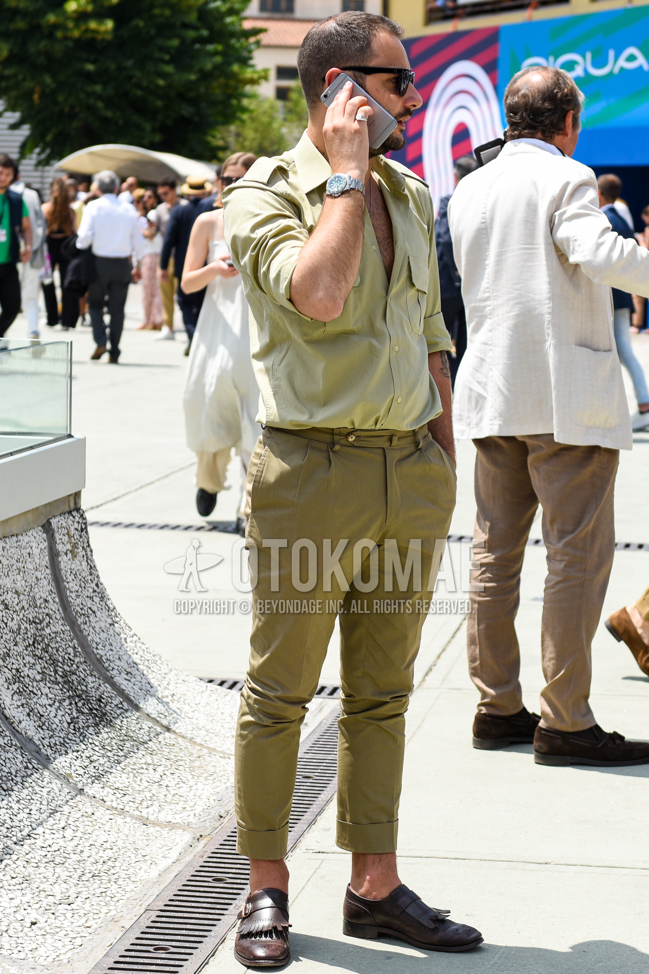 Men's spring summer autumn outfit with black plain sunglasses, olive green plain shirt, olive green plain beltless pants, brown monk shoes leather shoes.