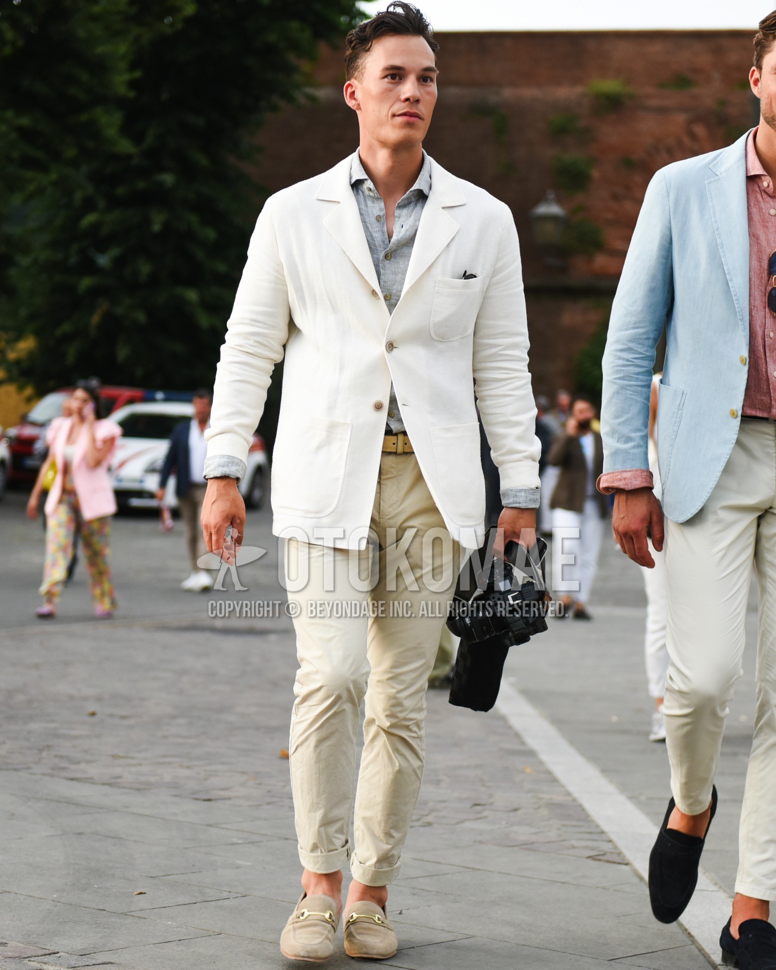 Men's spring summer outfit with white plain tailored jacket, gray plain shirt, brown plain leather belt, beige plain chinos, beige bit loafers leather shoes.