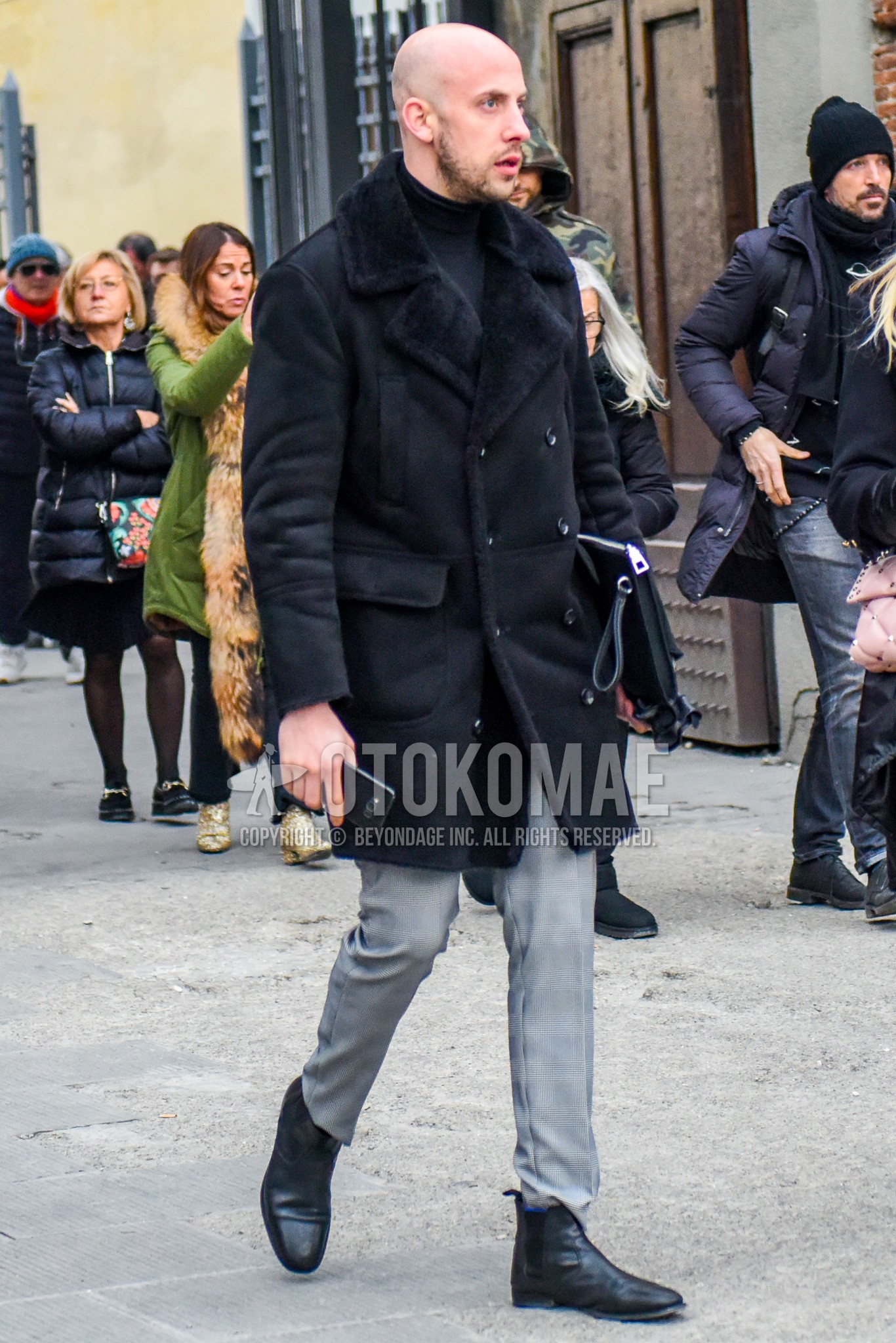 Men's winter outfit with black plain leather jacket, black plain sweater, gray check slacks, black side-gore boots.