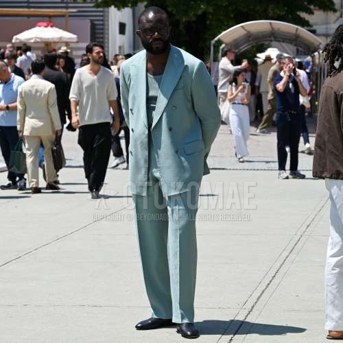 黒無地のメガネ、グリーン無地のタンクトップ、黒の革靴、グリーン無地のスーツを合わせた夏春のメンズコーデ・着こなし。