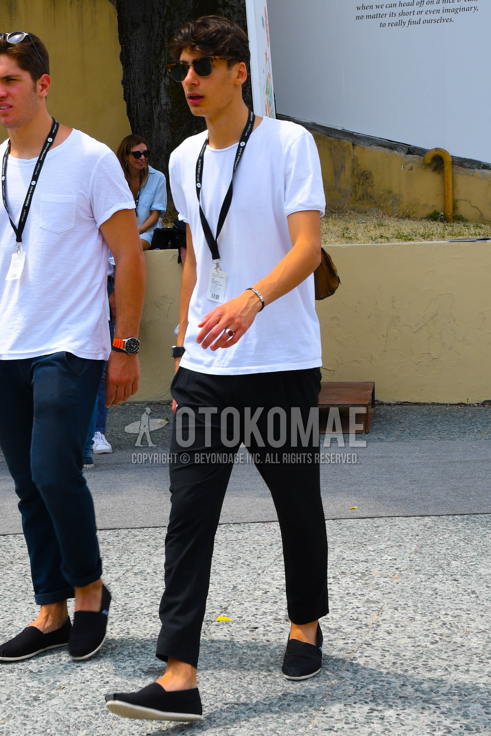 Men's summer outfit with plain sunglasses, white plain t-shirt, black plain slacks, navy slip-on sneakers.