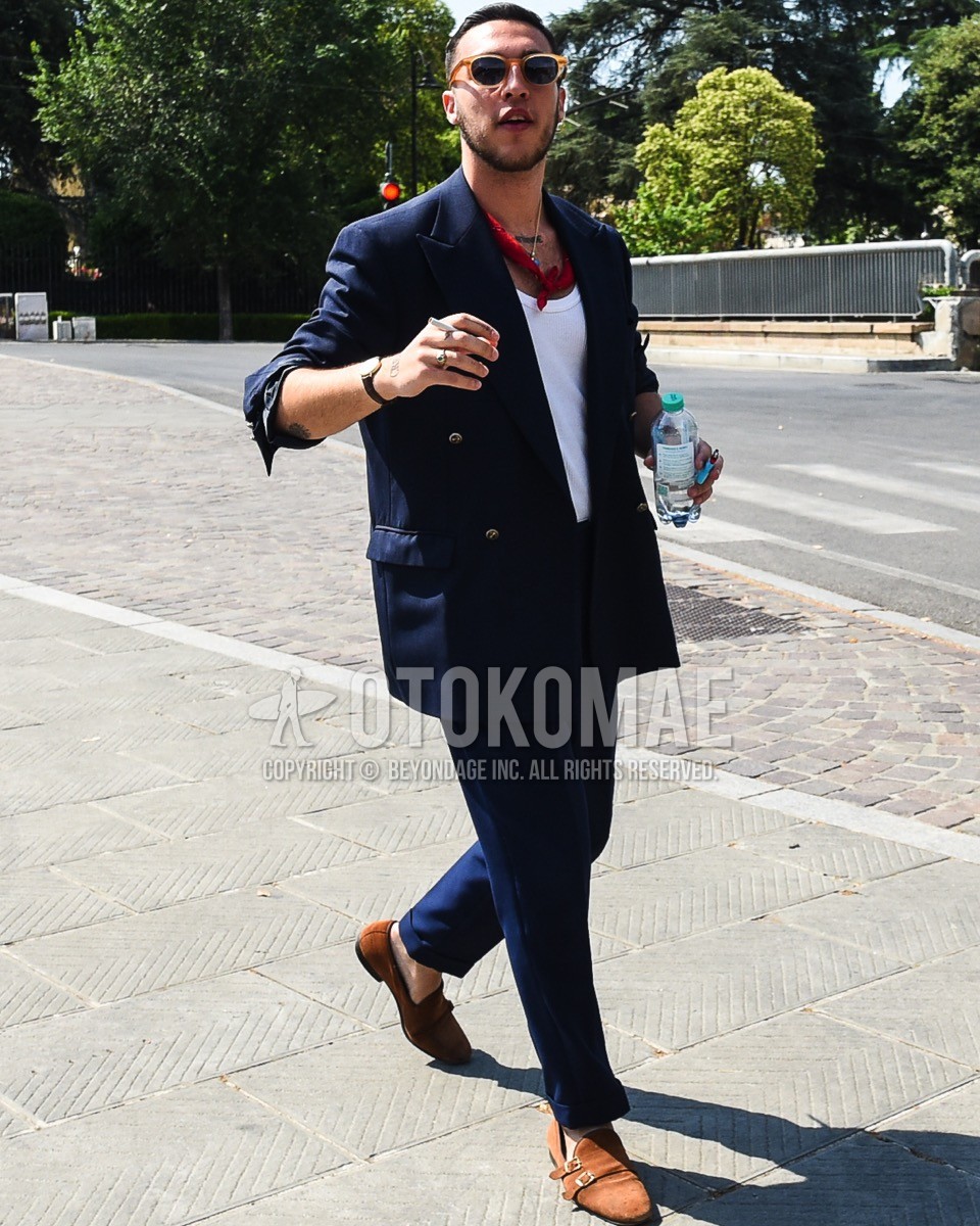 Men's spring summer outfit with brown plain sunglasses, red scarf bandana/neckerchief, plain tailored jacket, white plain tank top, brown monk shoes leather shoes, navy plain suit.