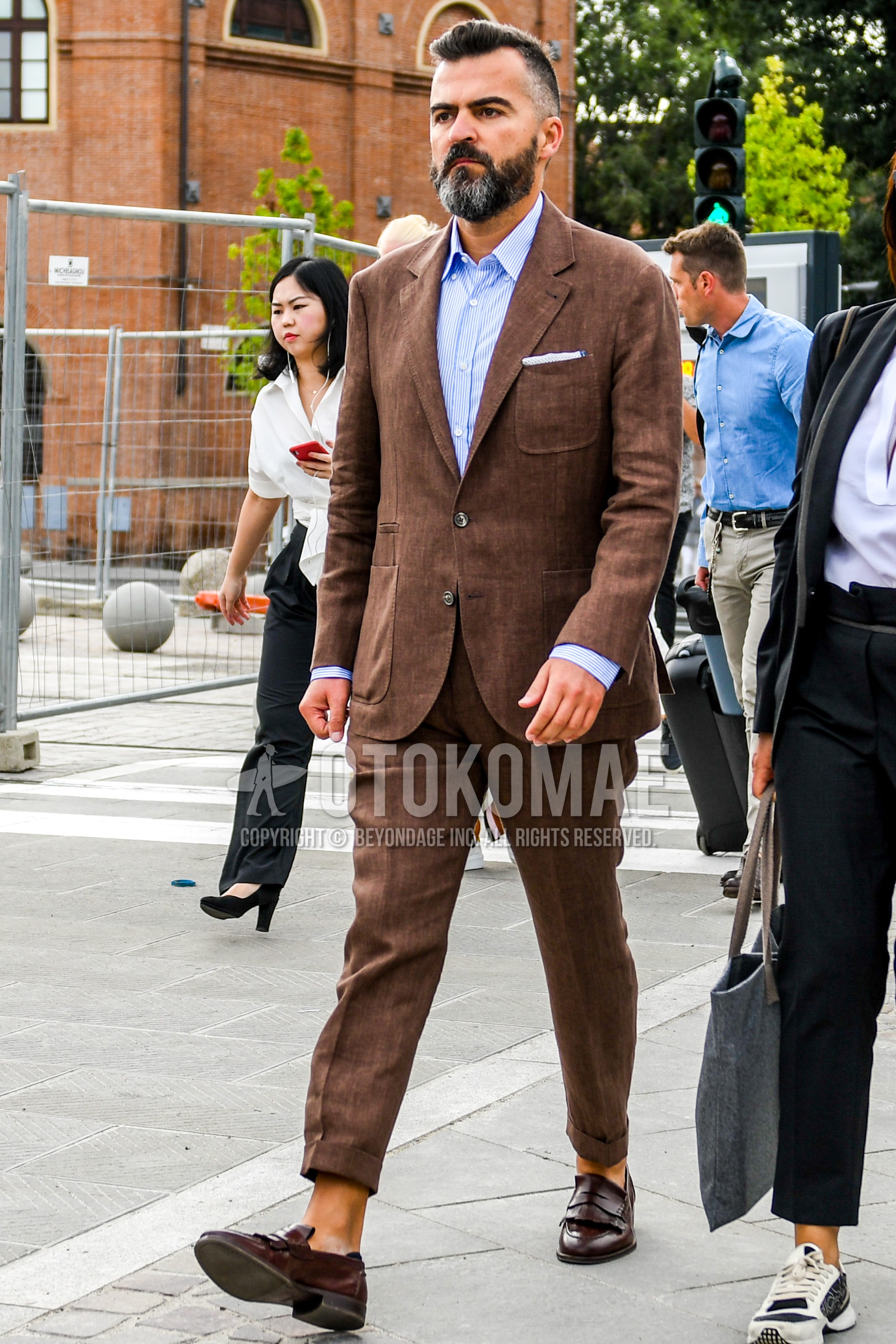 Men's spring summer autumn outfit with light blue plain shirt, brown coin loafers leather shoes, brown plain suit.