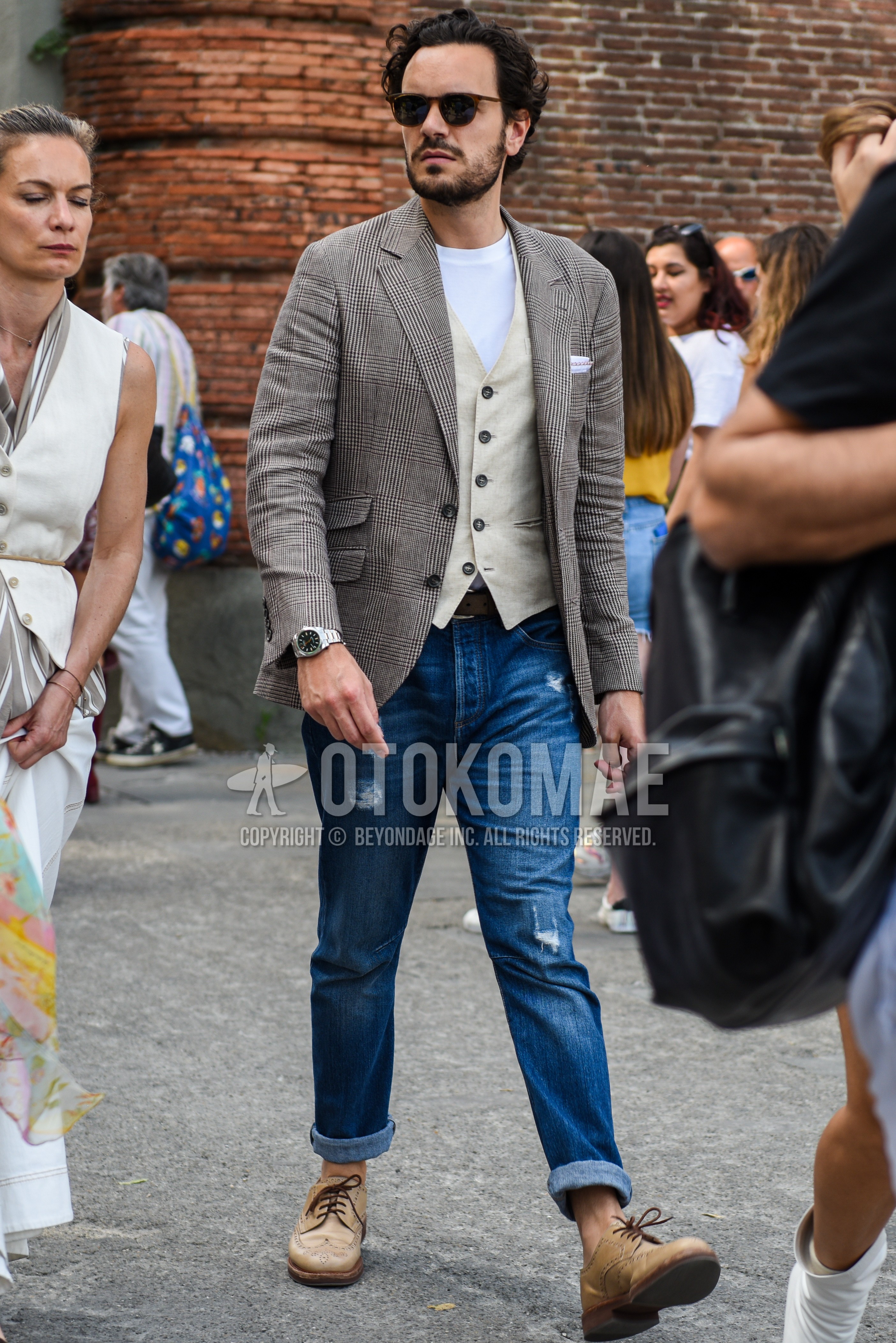Men's spring summer autumn outfit with black brown tortoiseshell sunglasses, gray brown check tailored jacket, white plain t-shirt, white beige plain gilet, blue plain damaged jeans, beige brogue shoes leather shoes.
