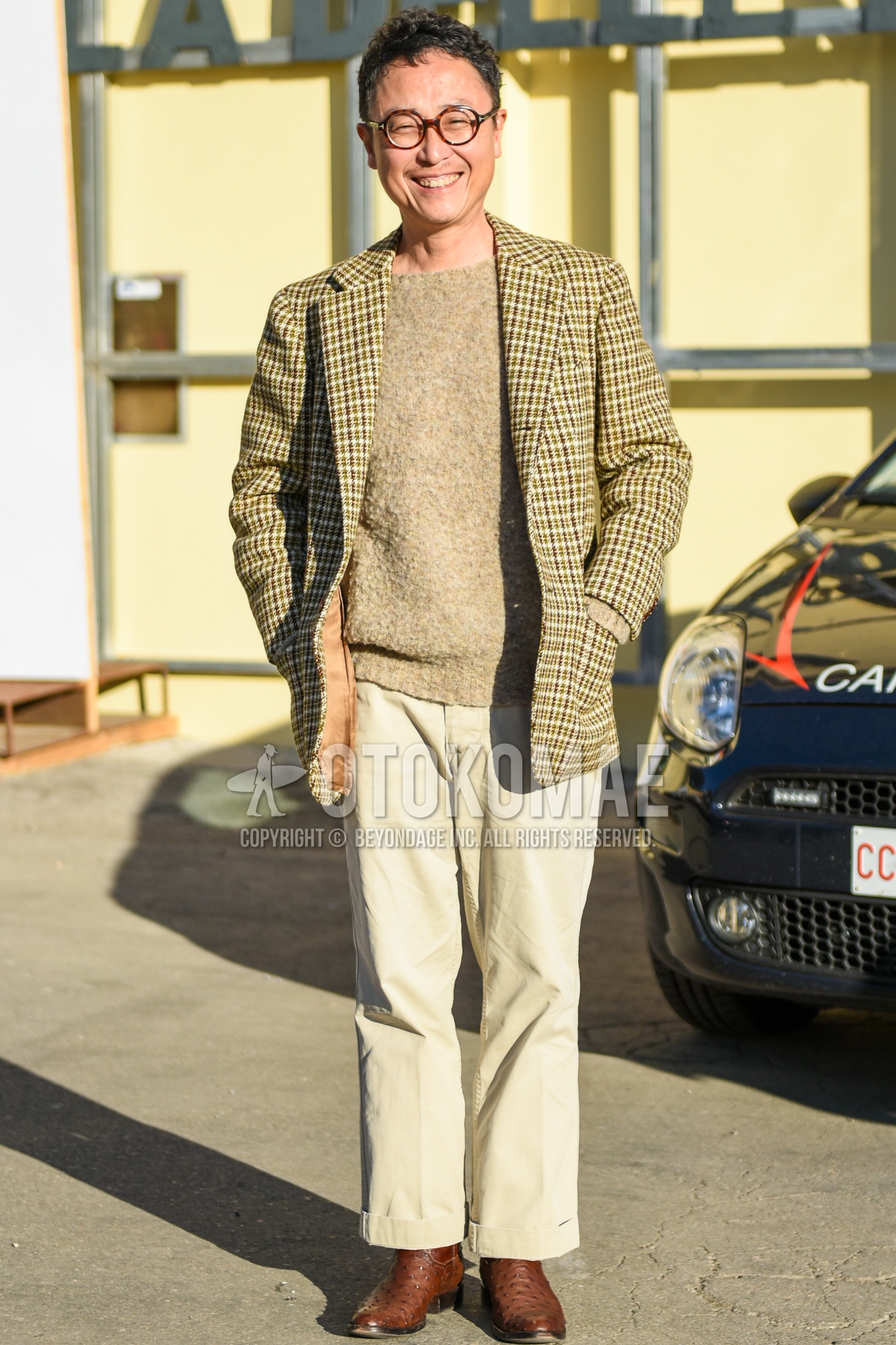 Men's spring autumn outfit with brown tortoiseshell glasses, beige check tailored jacket, beige plain sweater, beige plain chinos, brown  boots.