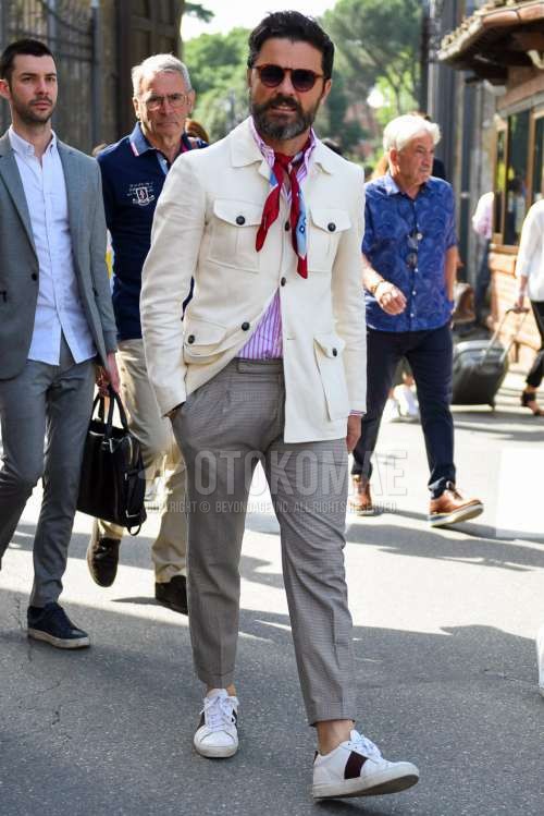 ボストンのブラウンべっ甲のサングラス、マルチカラーストールのバンダナ/ネッカチーフ、白無地のシャツジャケット、ピンクストライプのシャツ、グレー無地のベルトレスパンツ、白ローカットのスニーカーを合わせた春秋のメンズコーデ・着こなし。