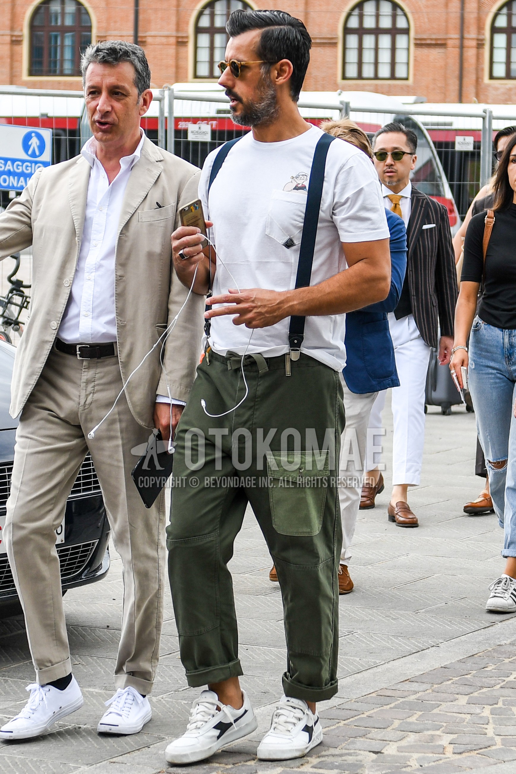 Men's summer outfit with white one point t-shirt, navy plain suspenders, olive green plain cargo pants, white low-cut sneakers.