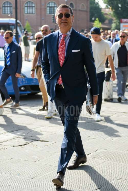 ゴールド無地のサングラス、白・ブルーストライプのシャツ、ブラウンプレーントゥの革靴、レッドネクタイのネクタイを合わせた春秋のメンズコーデ・着こなし。