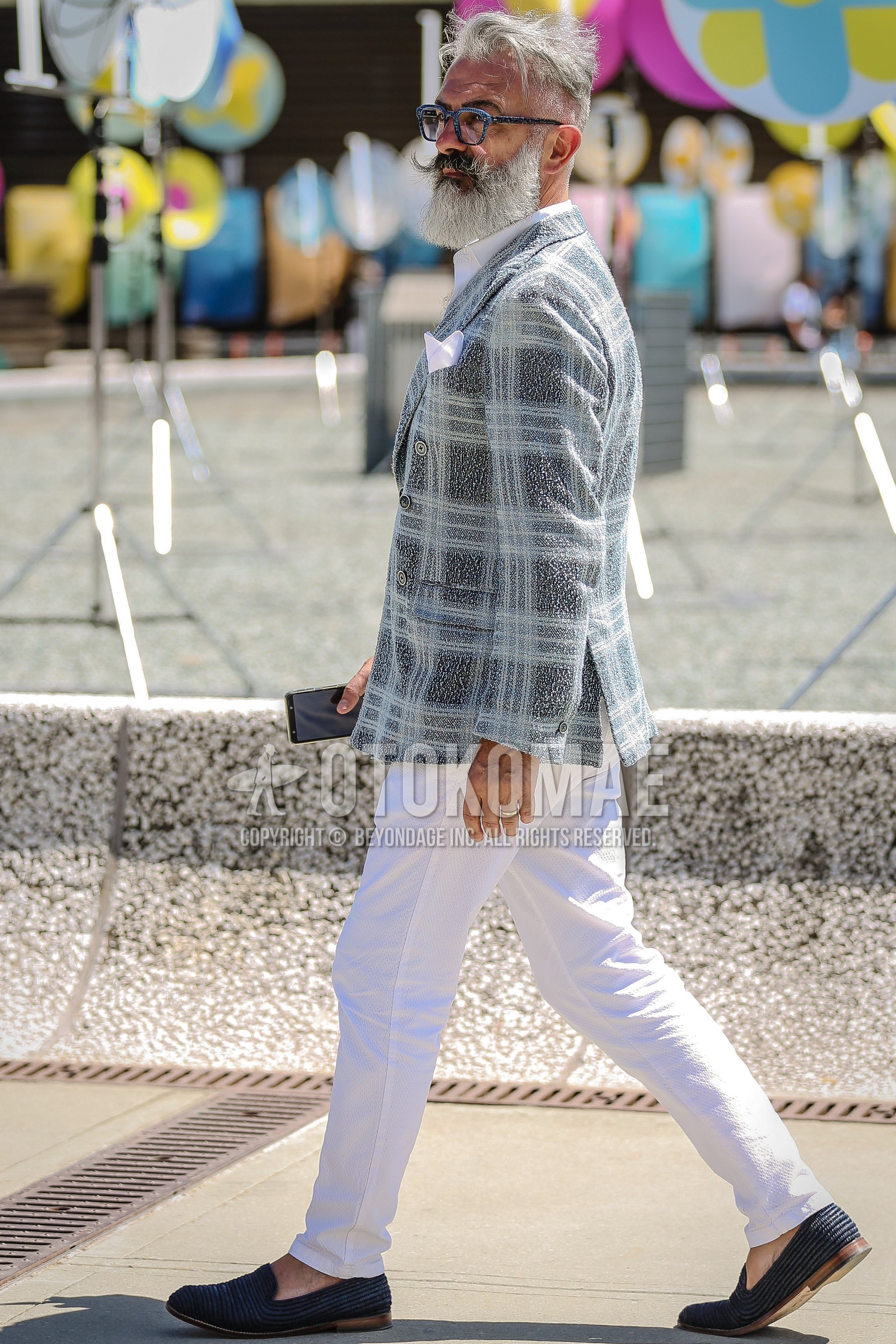 Men's spring summer outfit with blue eyewear glasses, light blue check tailored jacket, white plain shirt, white plain slacks, navy  loafers leather shoes.