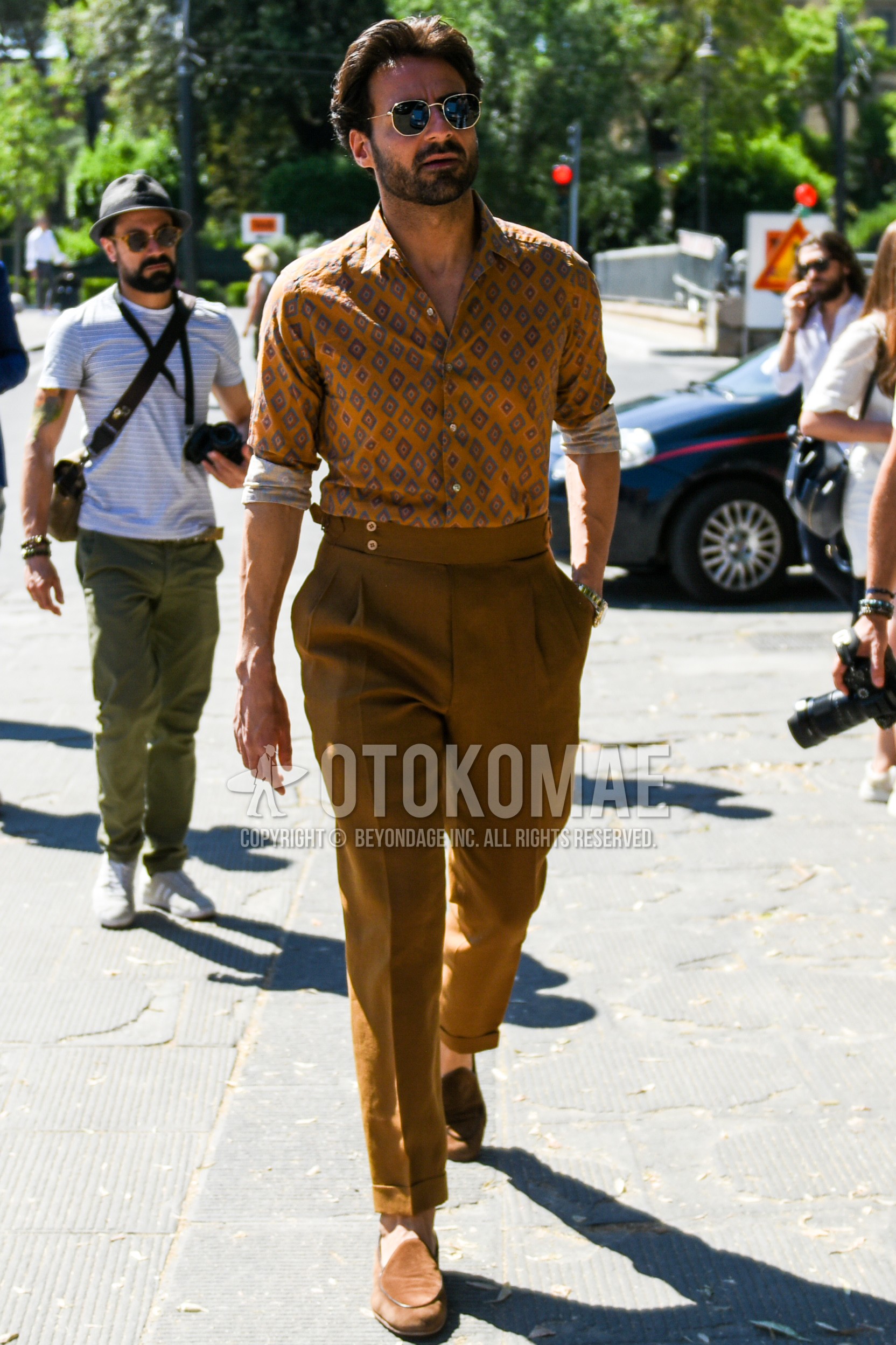 Men's spring summer outfit with black gold plain sunglasses, beige tops/innerwear shirt, brown plain beltless pants, plain ankle pants, brown  loafers leather shoes.