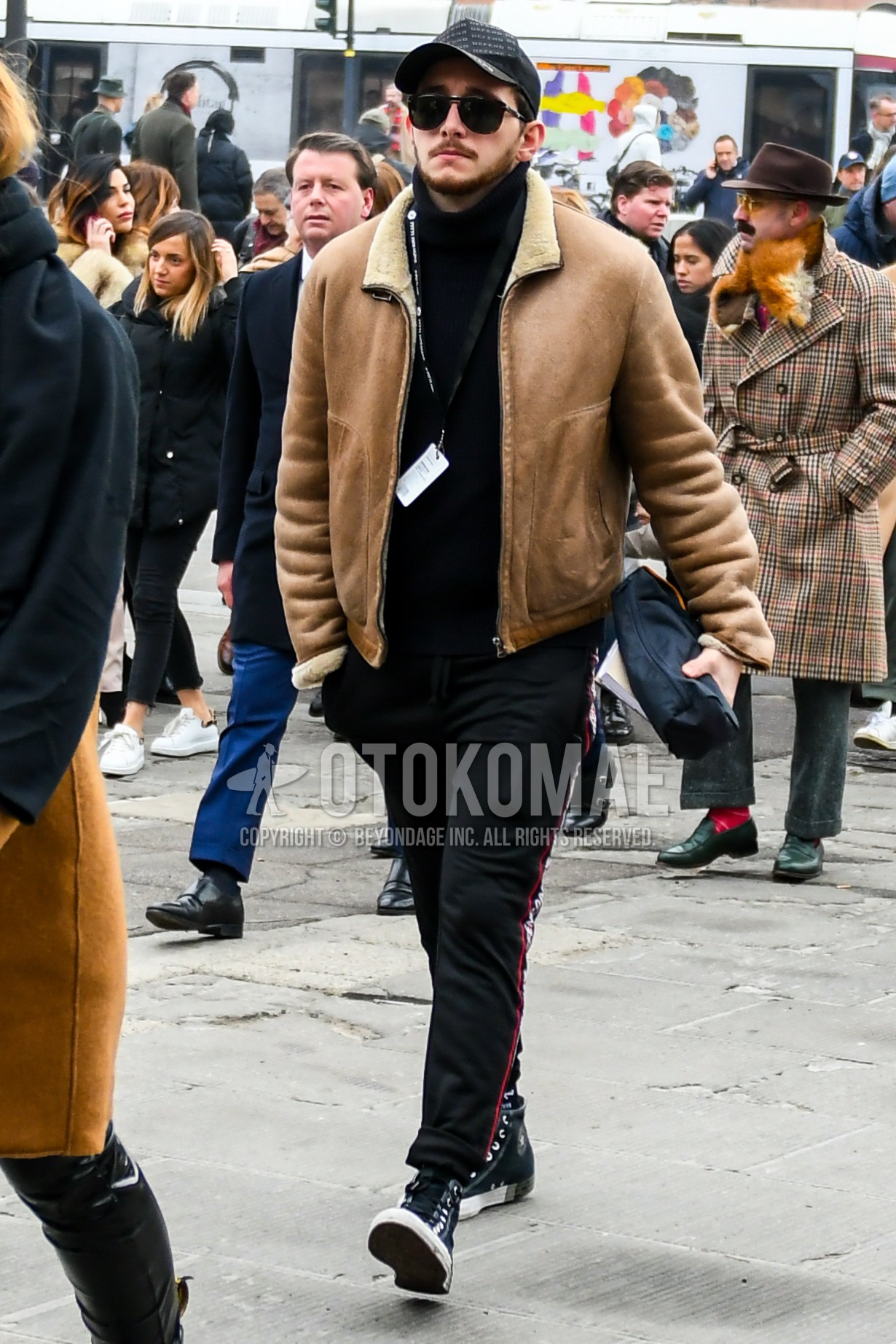 Men's autumn winter outfit with plain baseball cap, plain sunglasses, brown plain leather jacket, black plain turtleneck knit, black plain sideline pants, black high-cut sneakers.