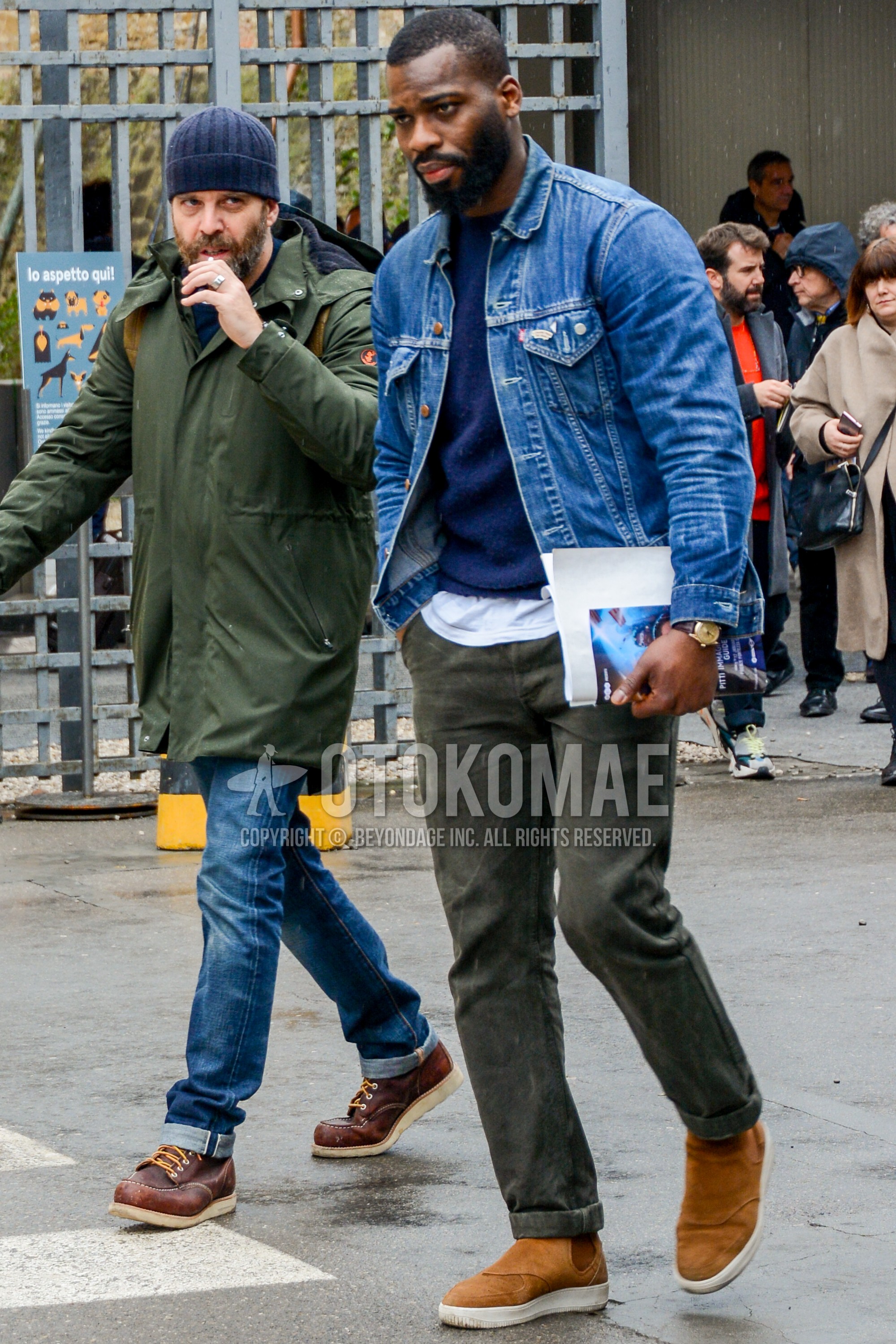 Men's winter outfit with blue plain denim jacket, navy plain sweater, gray plain cotton pants, brown high-cut sneakers.