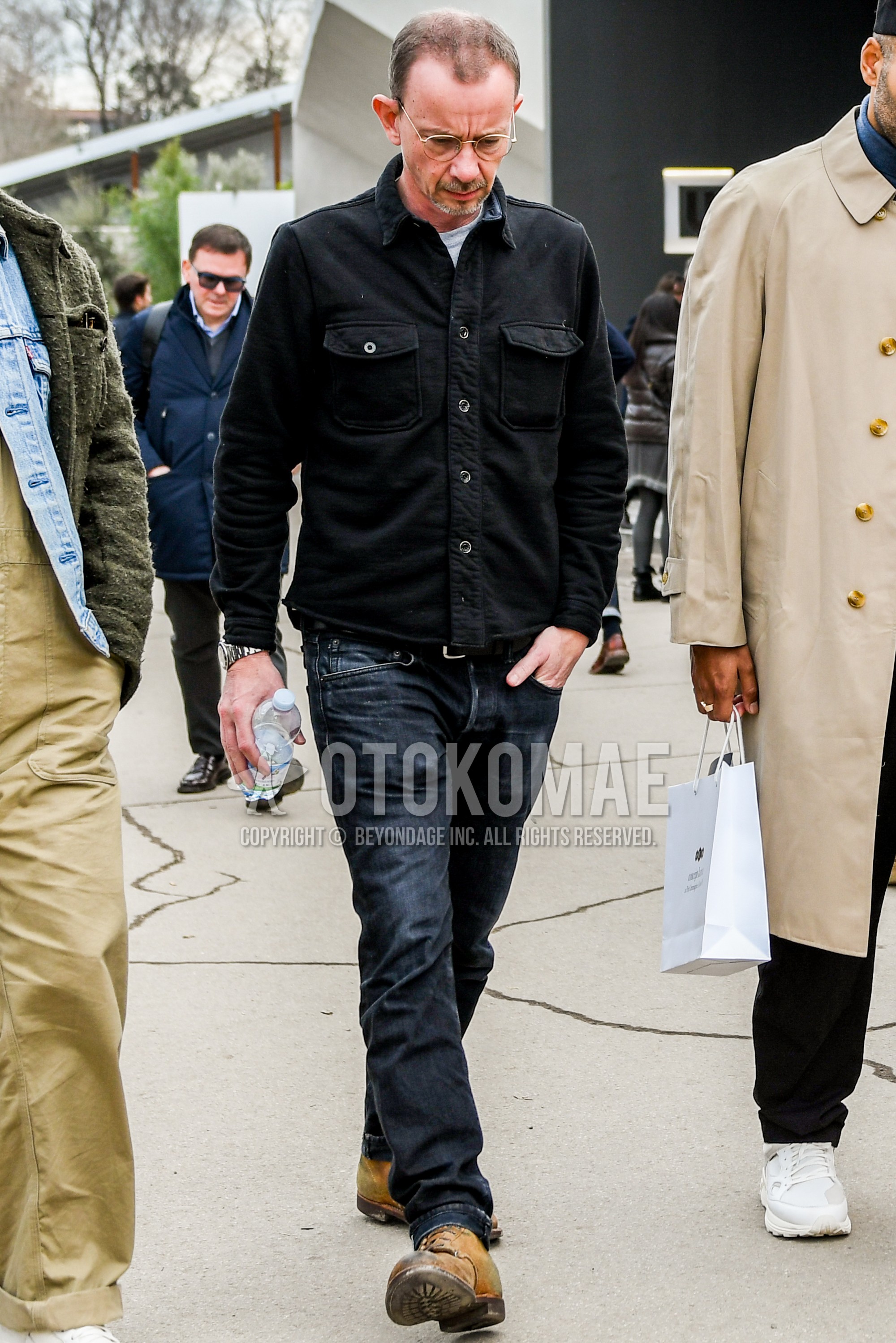 Men's winter outfit with plain glasses, black plain denim jacket, gray plain sweatshirt, black plain denim/jeans, brown  boots.