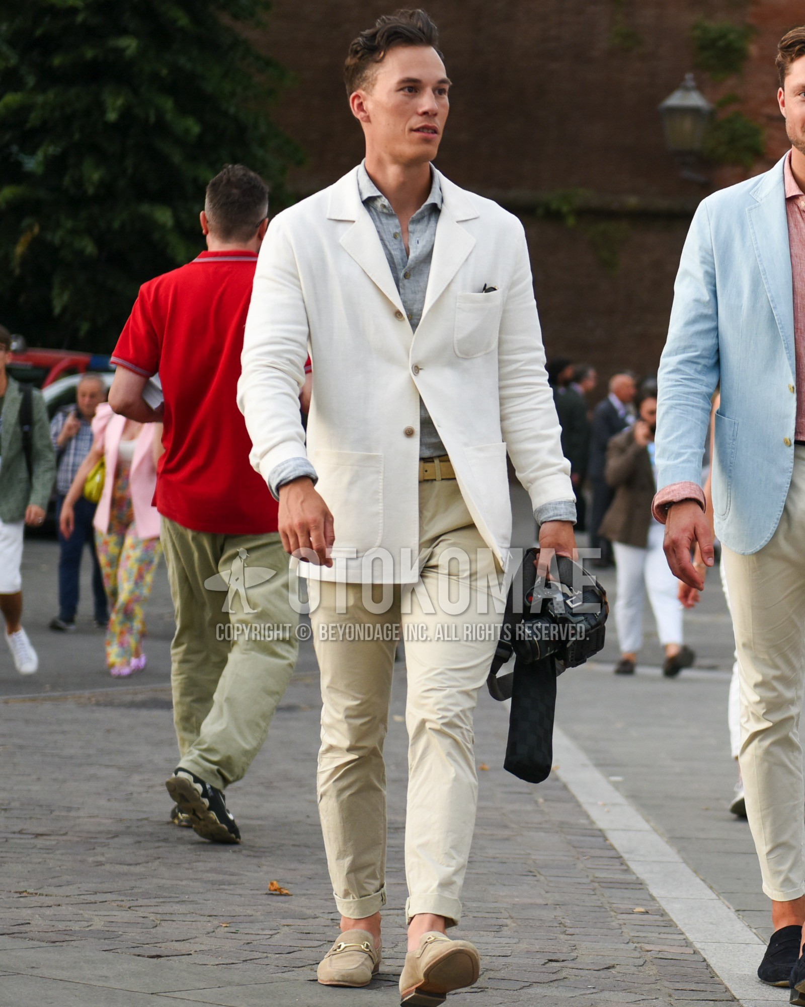 Men's spring summer outfit with white plain tailored jacket, gray plain shirt, beige plain leather belt, beige plain chinos, beige bit loafers leather shoes.