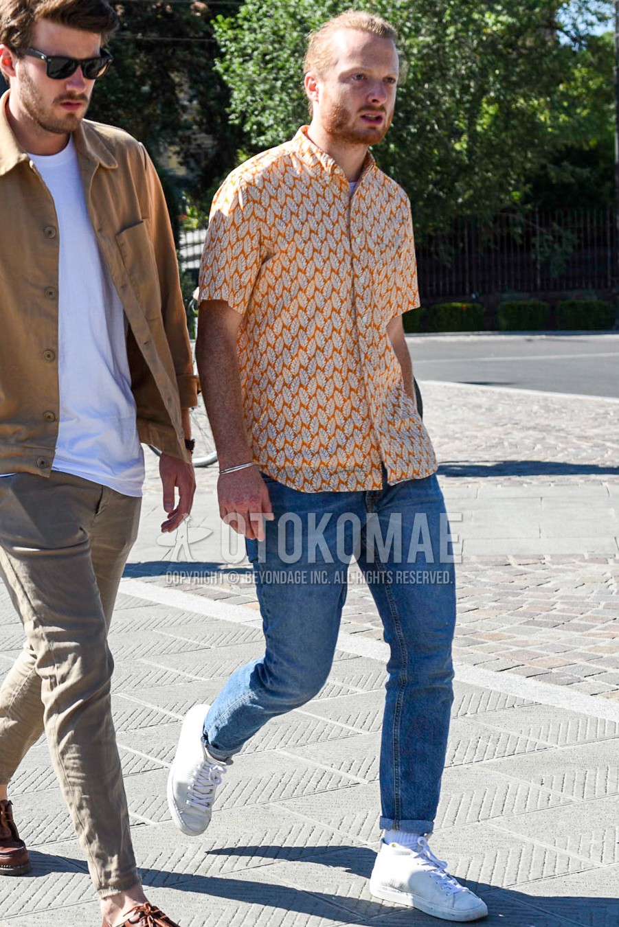 Men's summer outfit with orange tops/innerwear shirt, light blue plain denim/jeans, white plain socks, white low-cut sneakers.