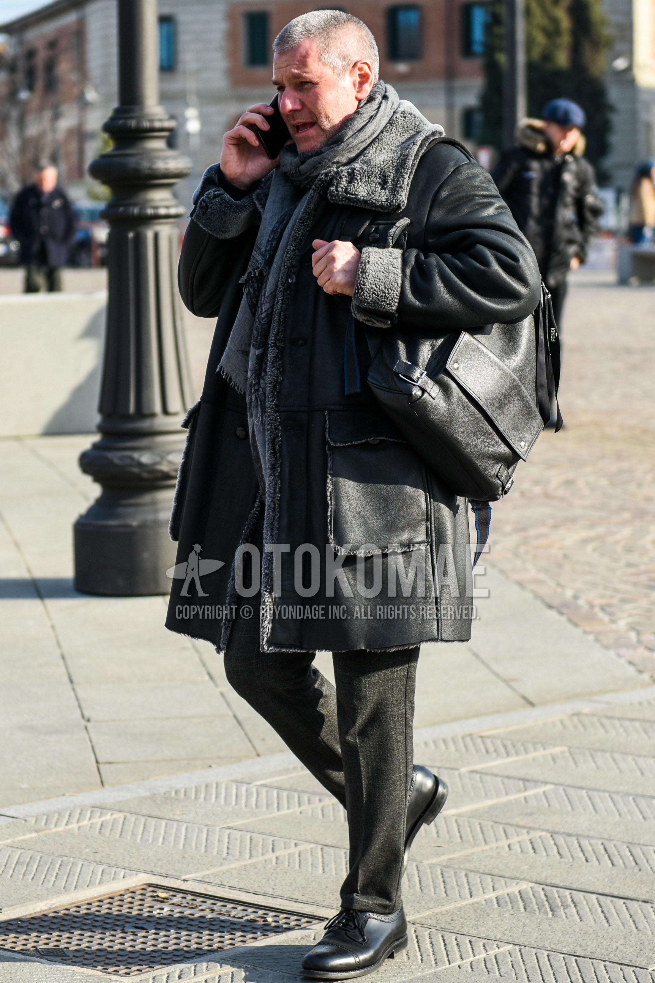 Men's winter outfit with gray plain scarf, black plain leather jacket, gray check slacks, black brogue shoes leather shoes, black plain backpack.