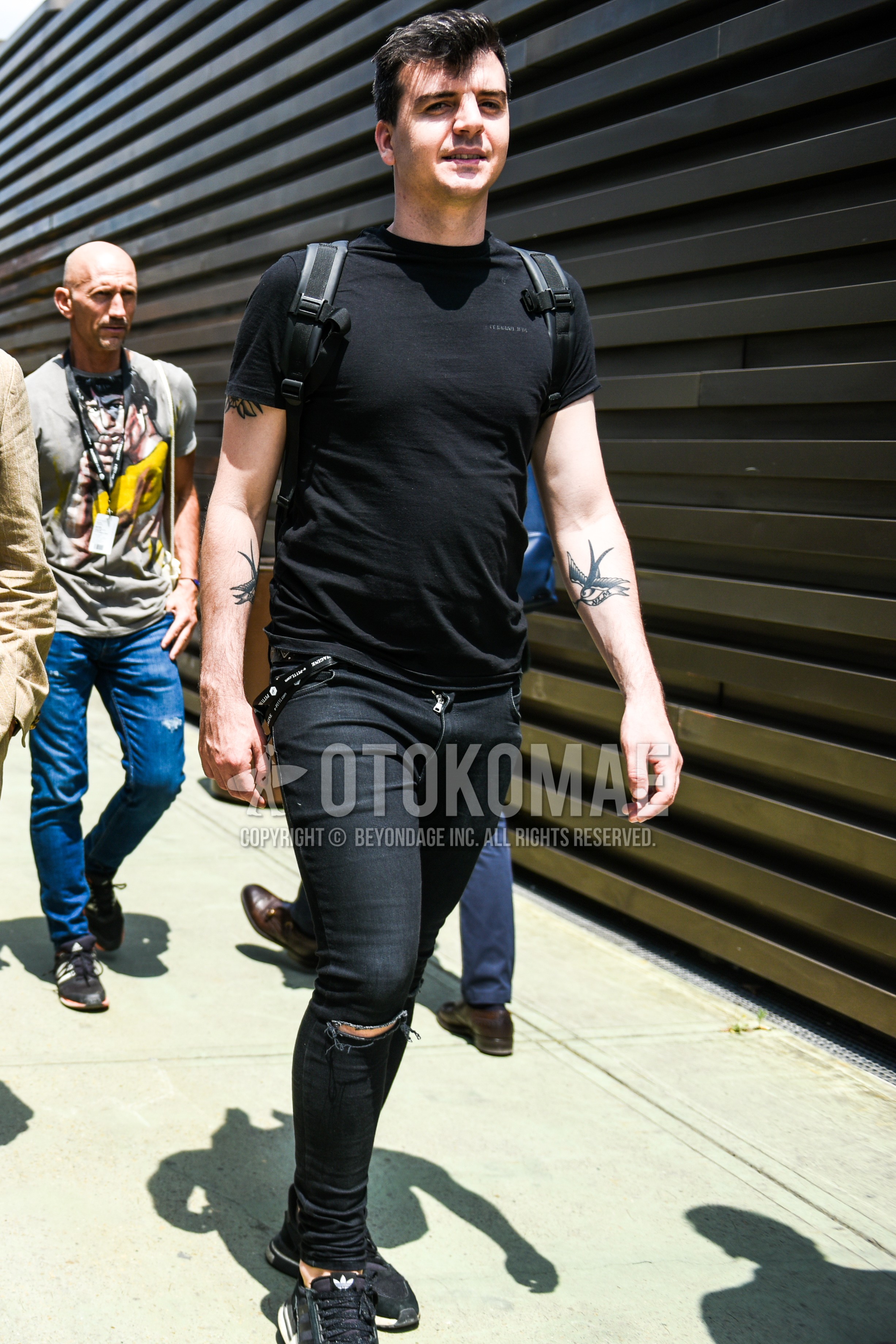 Men's summer outfit with black one point t-shirt, black plain damaged jeans, black low-cut sneakers.