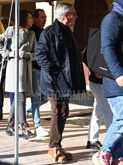 黒無地のメガネ、ネイビー無地のトレンチコート、黒無地のフリースジャケット、黒無地のタートルネックニット、ブラウン無地の冬パンツ(コーデュロイ,ベロア)、ブラウンUチップの革靴を合わせた秋冬のメンズコーデ・着こなし。