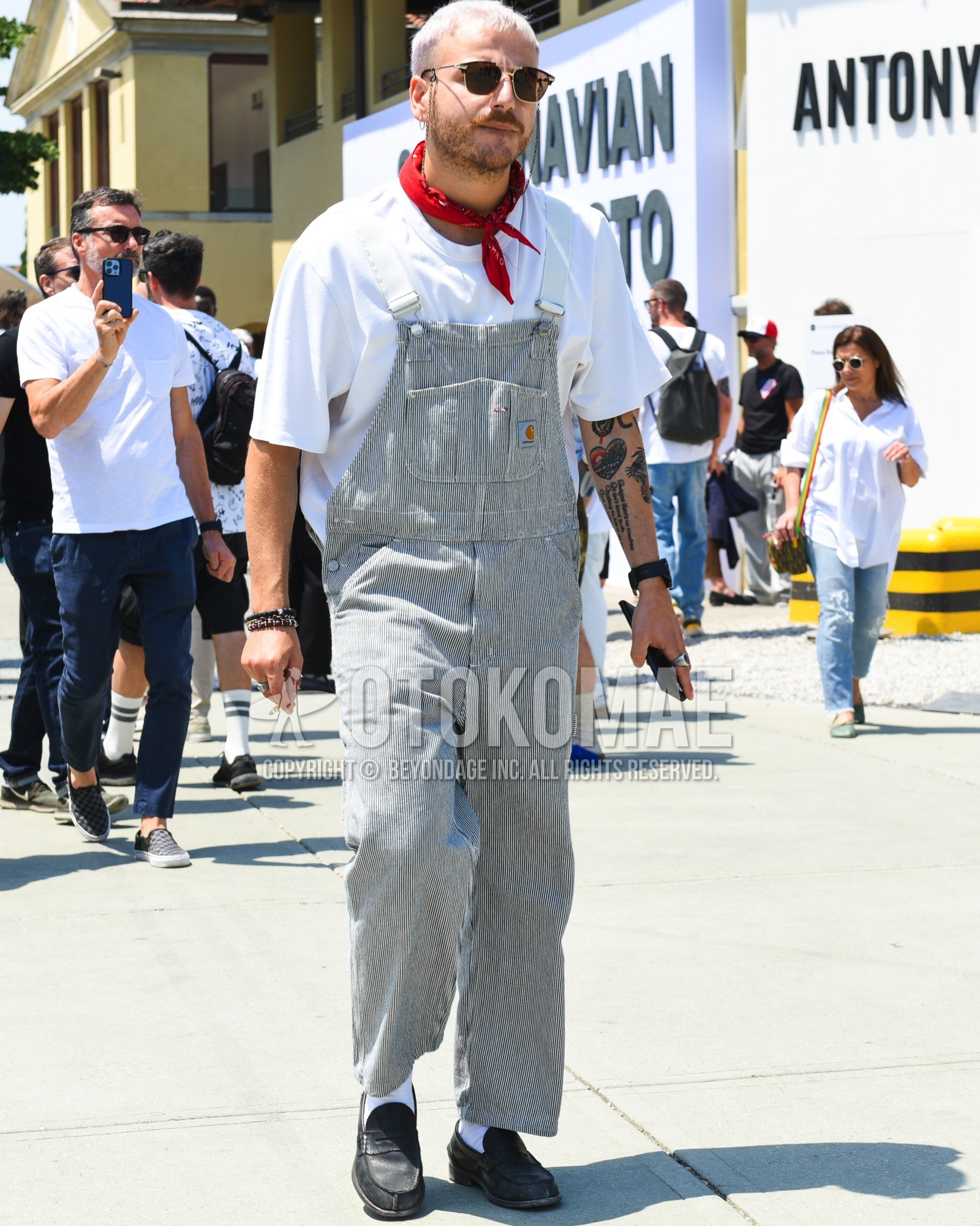 Men's spring summer outfit with black plain sunglasses, red scarf bandana/neckerchief, gray stripes jumpsuit, white plain t-shirt, white plain socks, black coin loafers leather shoes.