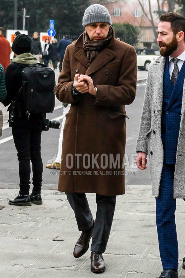 Men's winter outfit with gray plain knit cap, brown check scarf, brown plain ulster coat, dark gray check slacks, brown straight-tip shoes leather shoes.